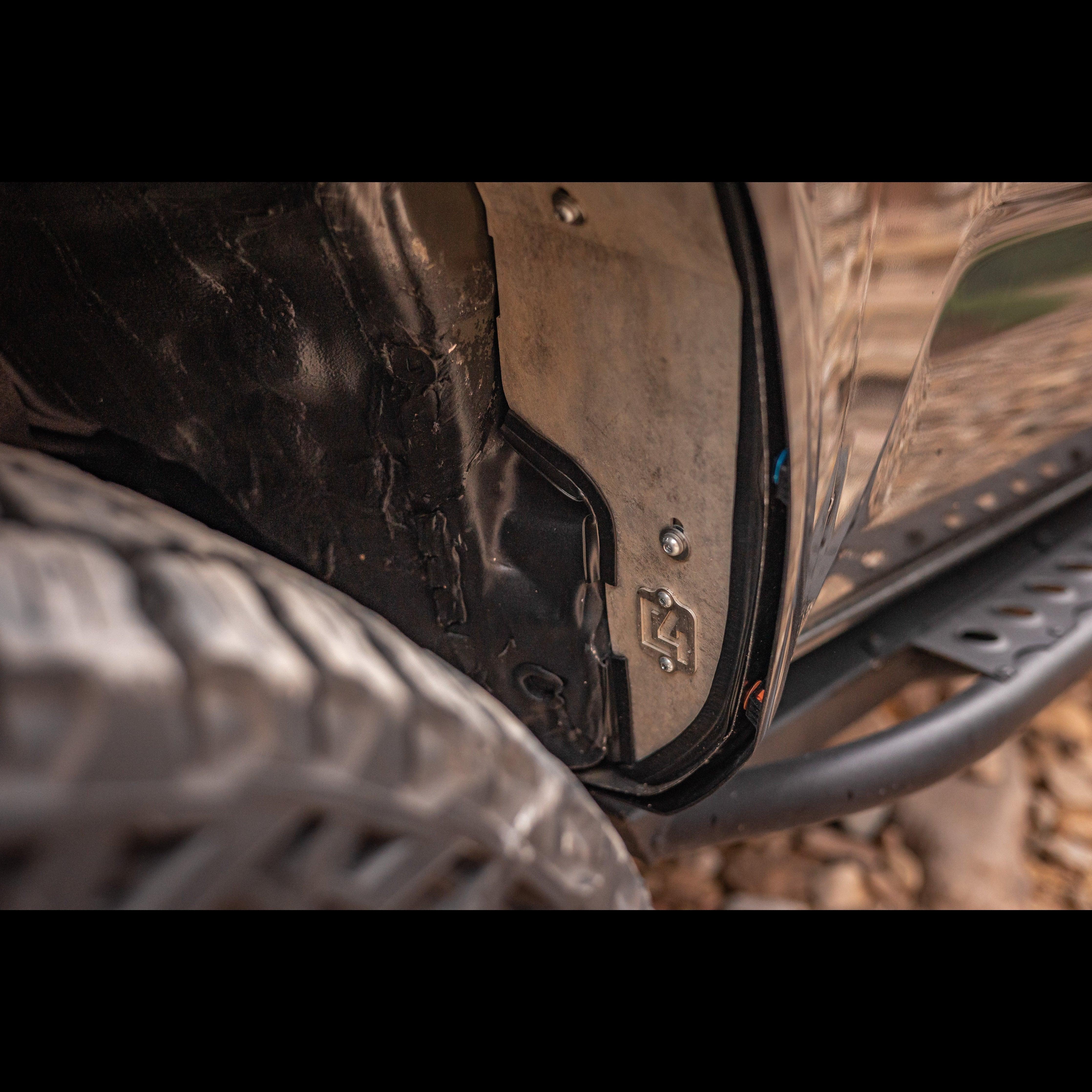 Close-up of off-road vehicle rock slider and metal door protection plate