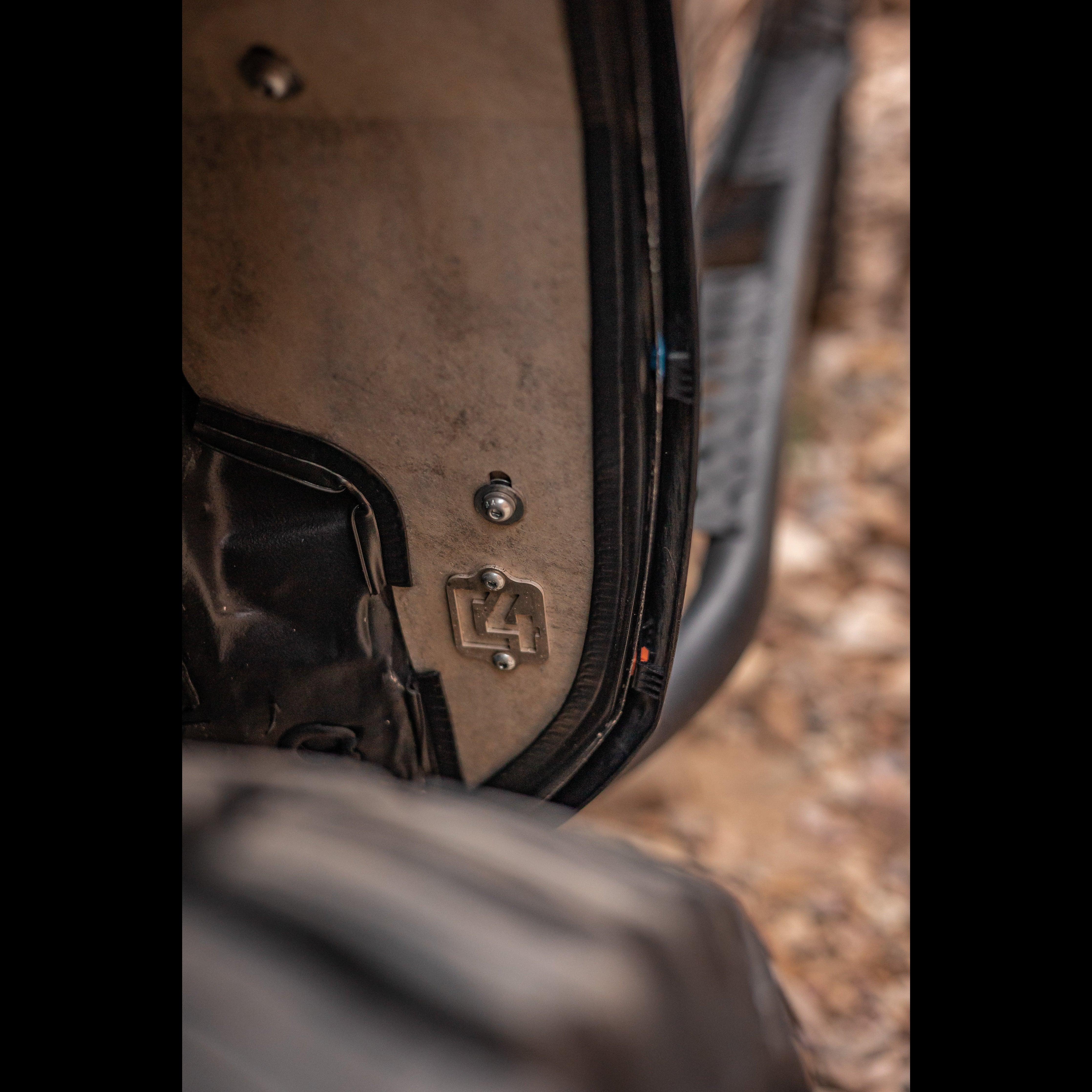 Close-up of an off-road vehicle door detail with bolt and metal bracket, overland gear