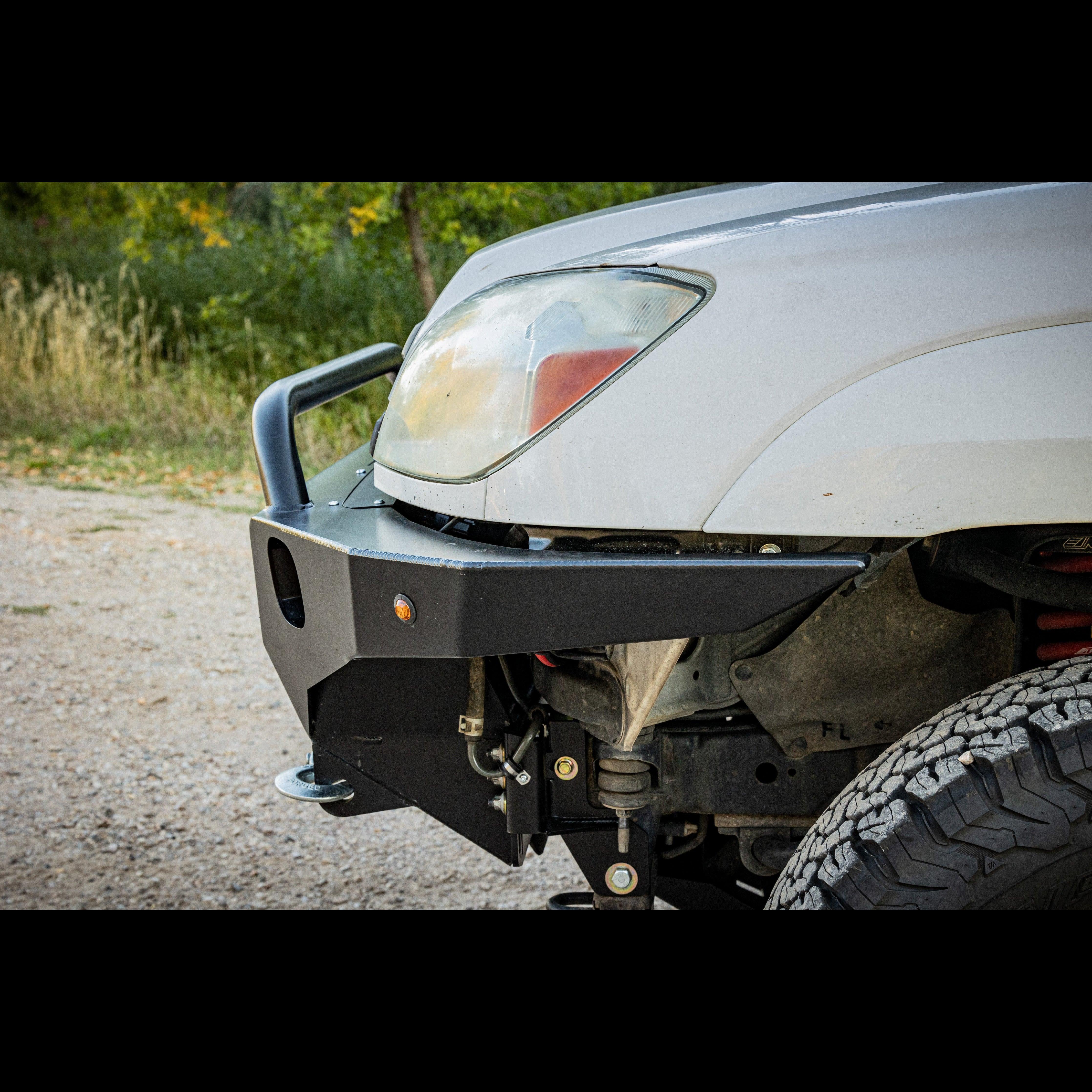 Aftermarket front bumper with winch mount on white Toyota Tacoma for overlanding