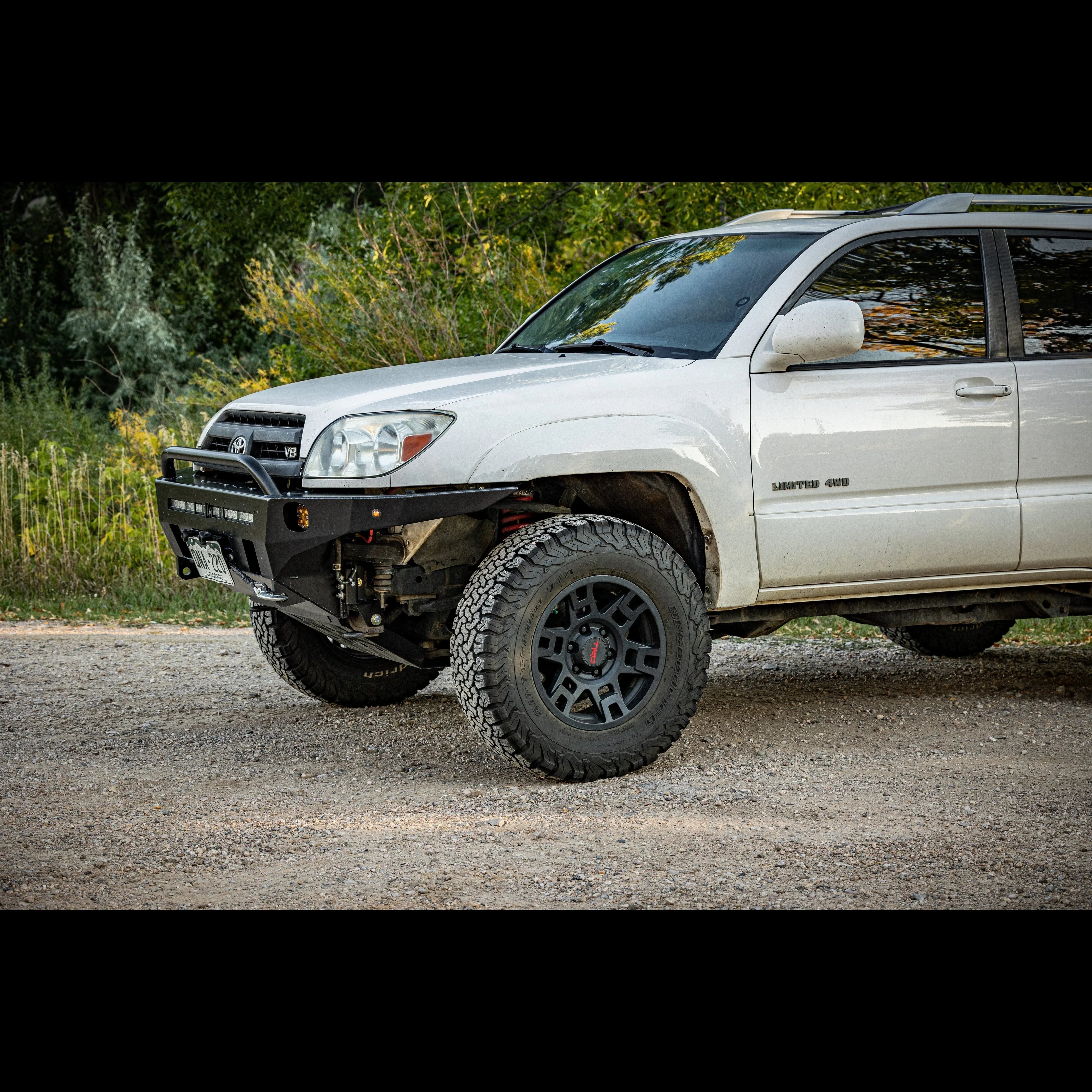 Toyota 4Runner with off-road bumper and rugged wheels parked on a gravel trail