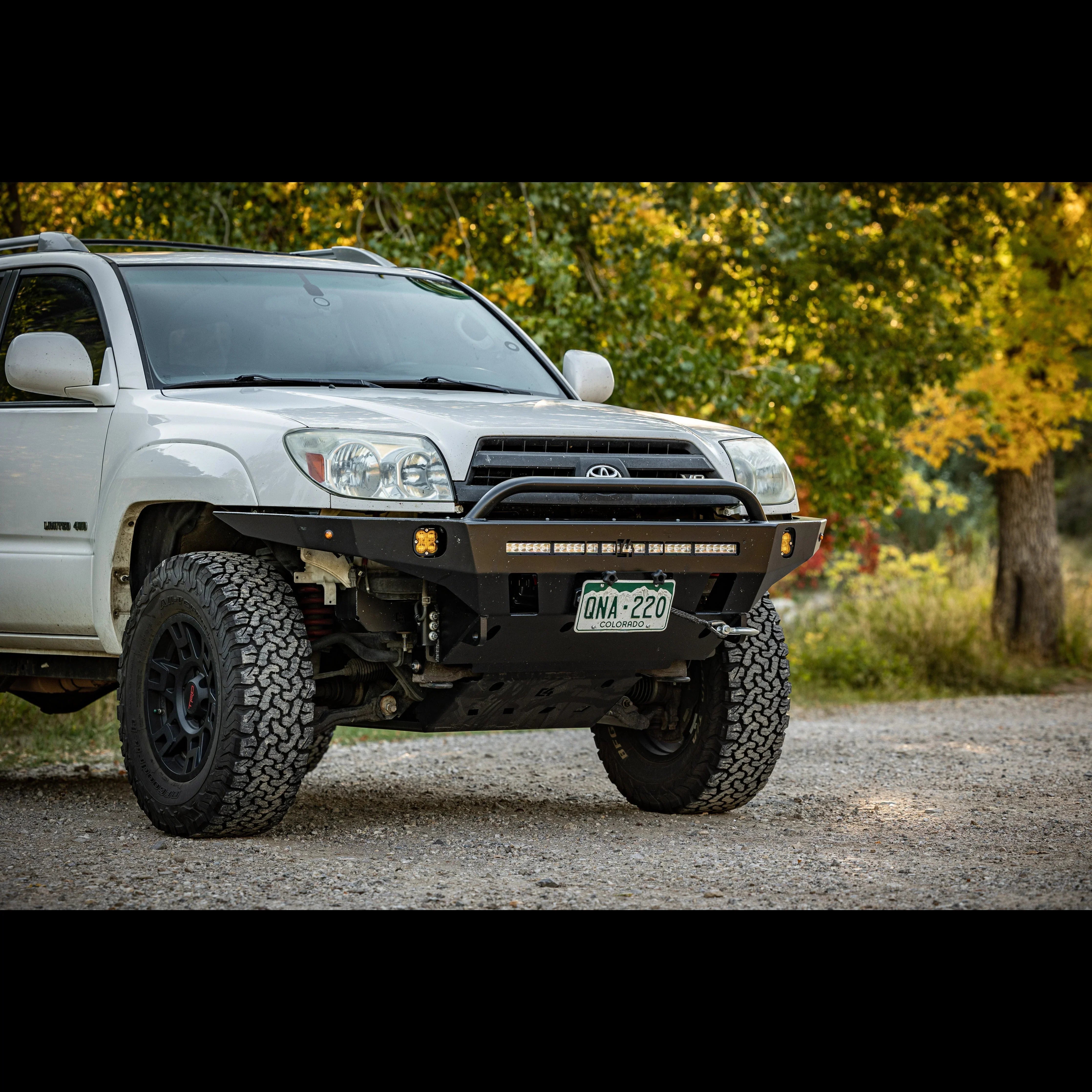 Toyota 4Runner with off-road front bumper and all-terrain tires parked on gravel road