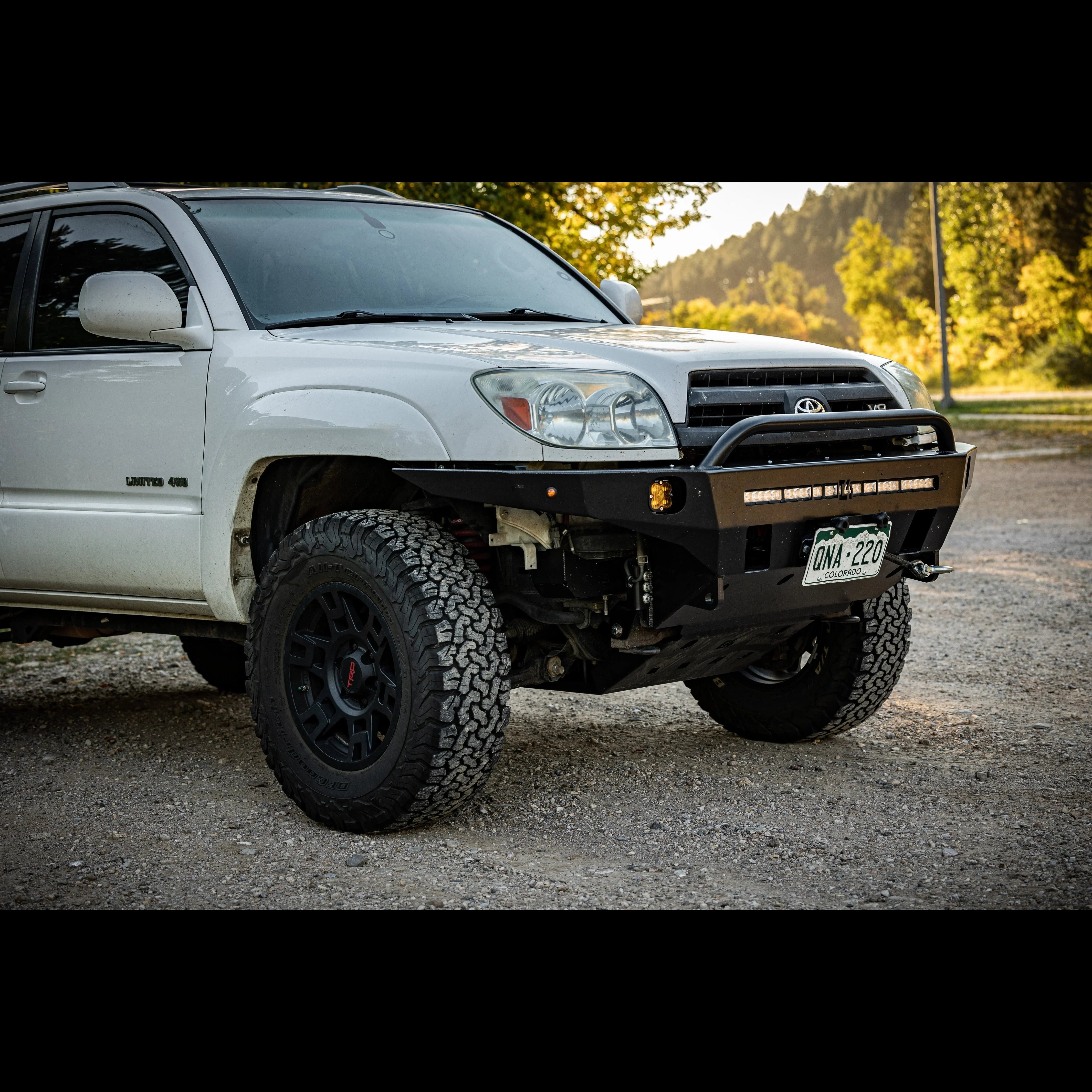 Toyota 4Runner with off-road front bumper, rugged tires, and LED light bar on gravel road