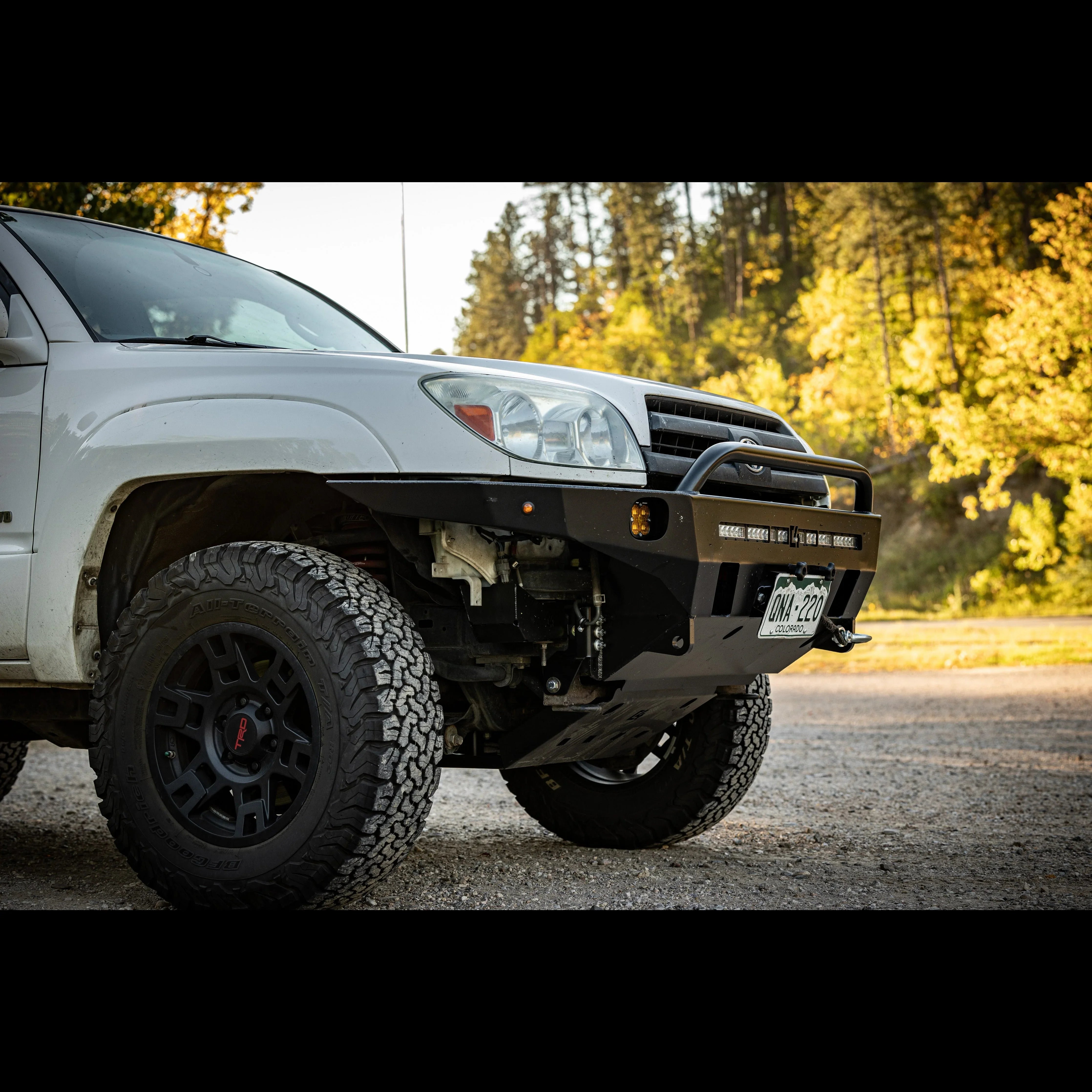 Toyota 4Runner with off-road front bumper, all-terrain tires and black TRD wheels outdoors