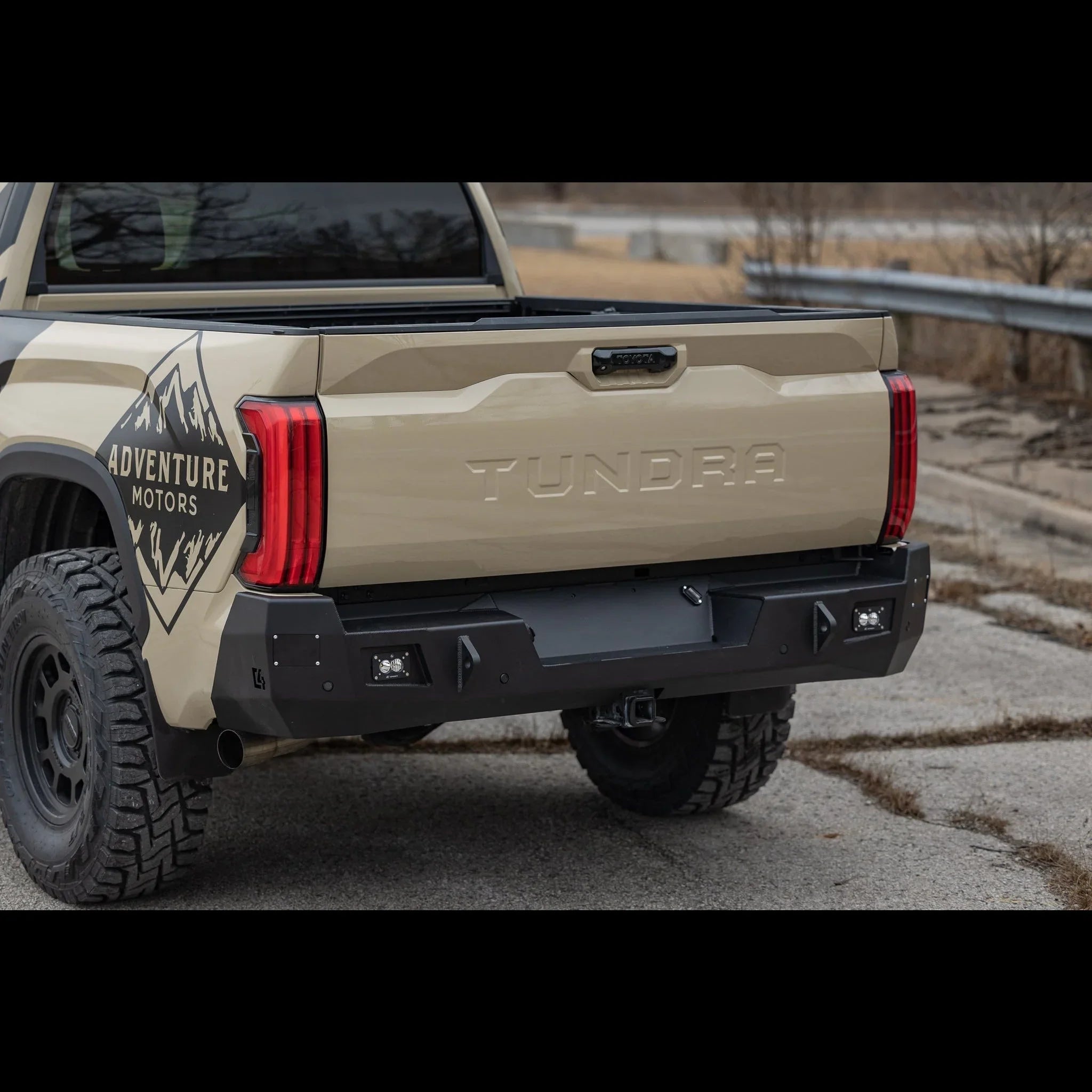 Toyota Tundra rear bumper with off-road lights and rugged adventure graphics in outdoor setting