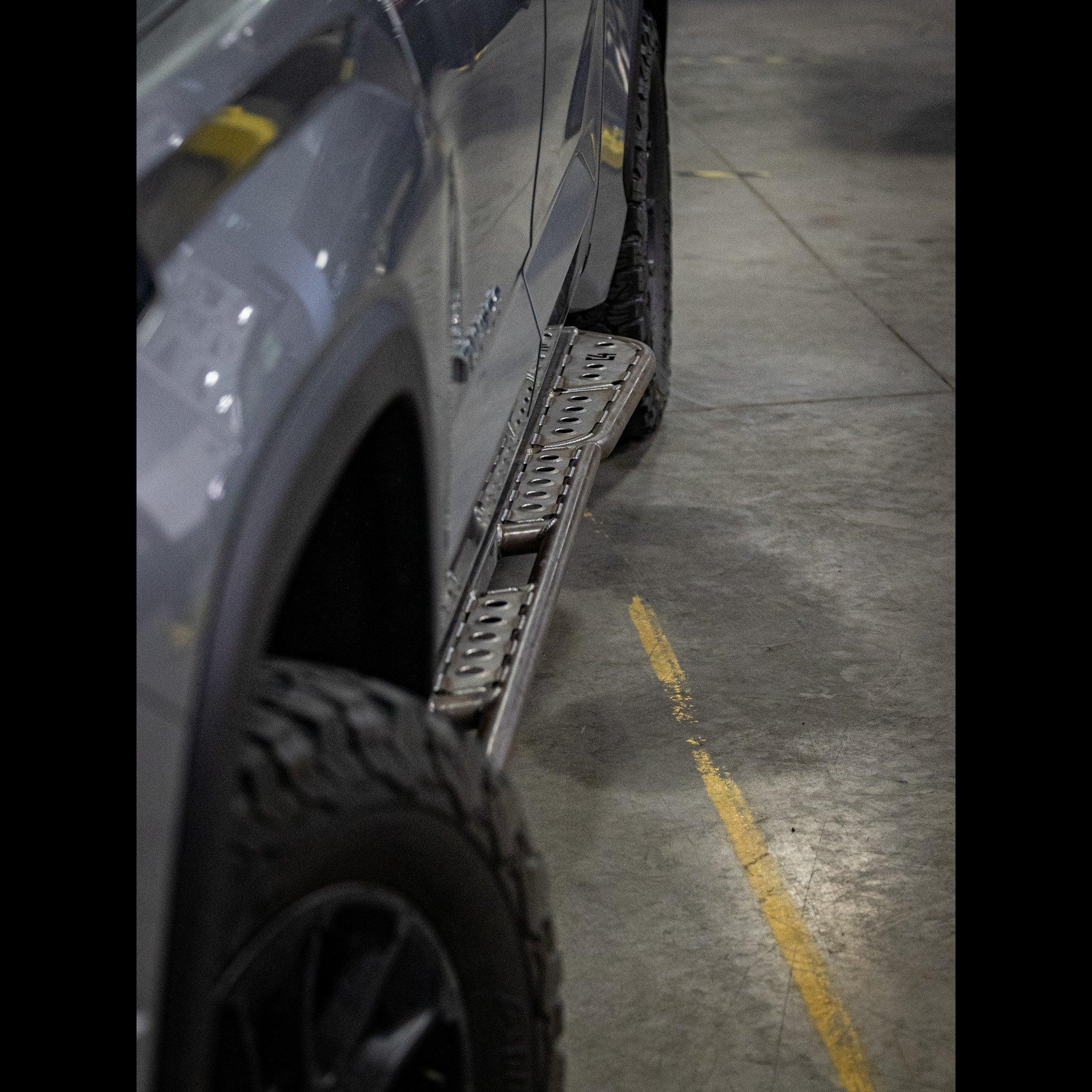 Toyota Tacoma with off-road steel side step rails in a garage setting