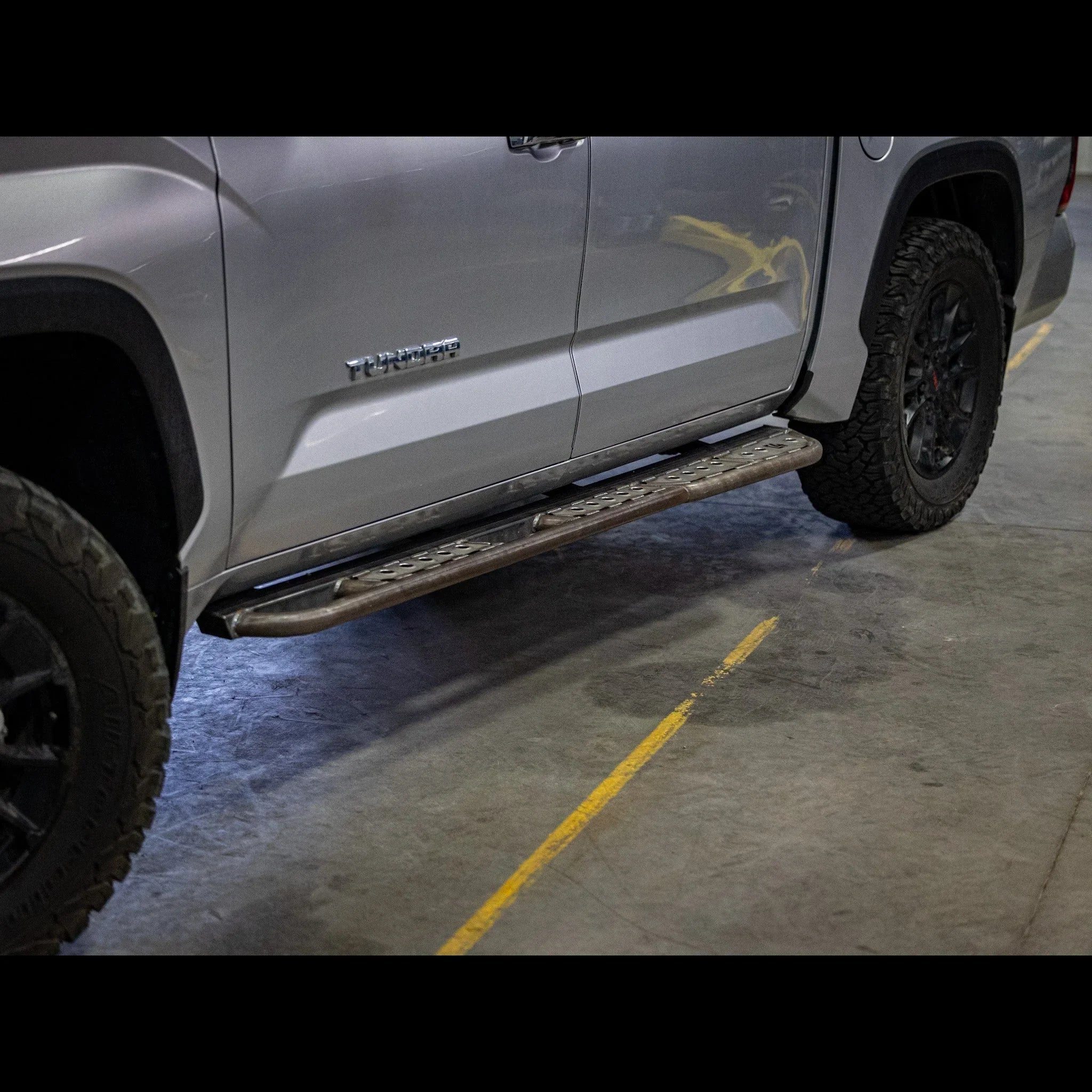 Steel rock slider step installed on Toyota Tundra truck, off-road accessory