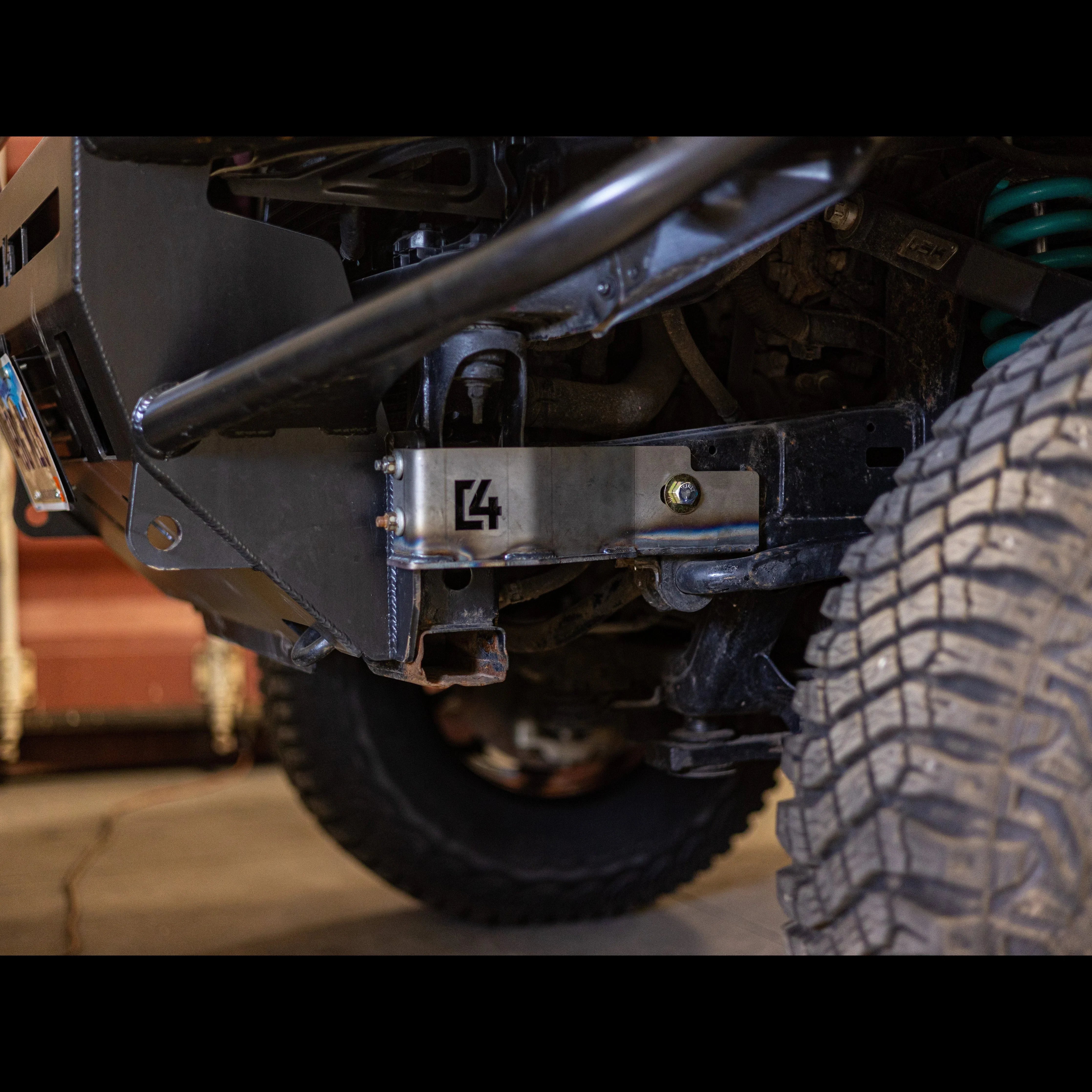 Off-road vehicle with heavy-duty steel bumper and skid plate, close-up of front suspension