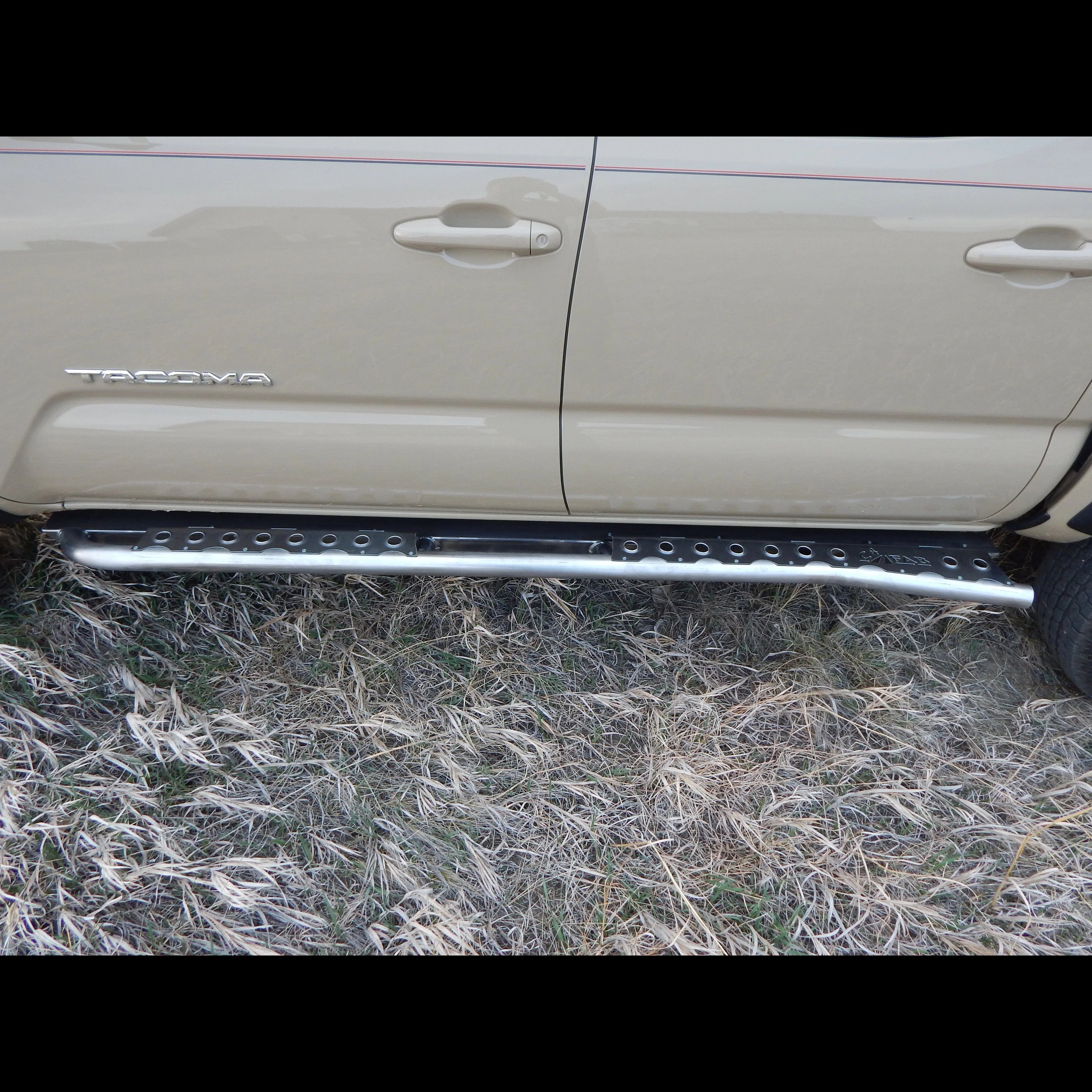 2016 Toyota Tacoma rock slider side step on tan truck, off-road accessory outdoors