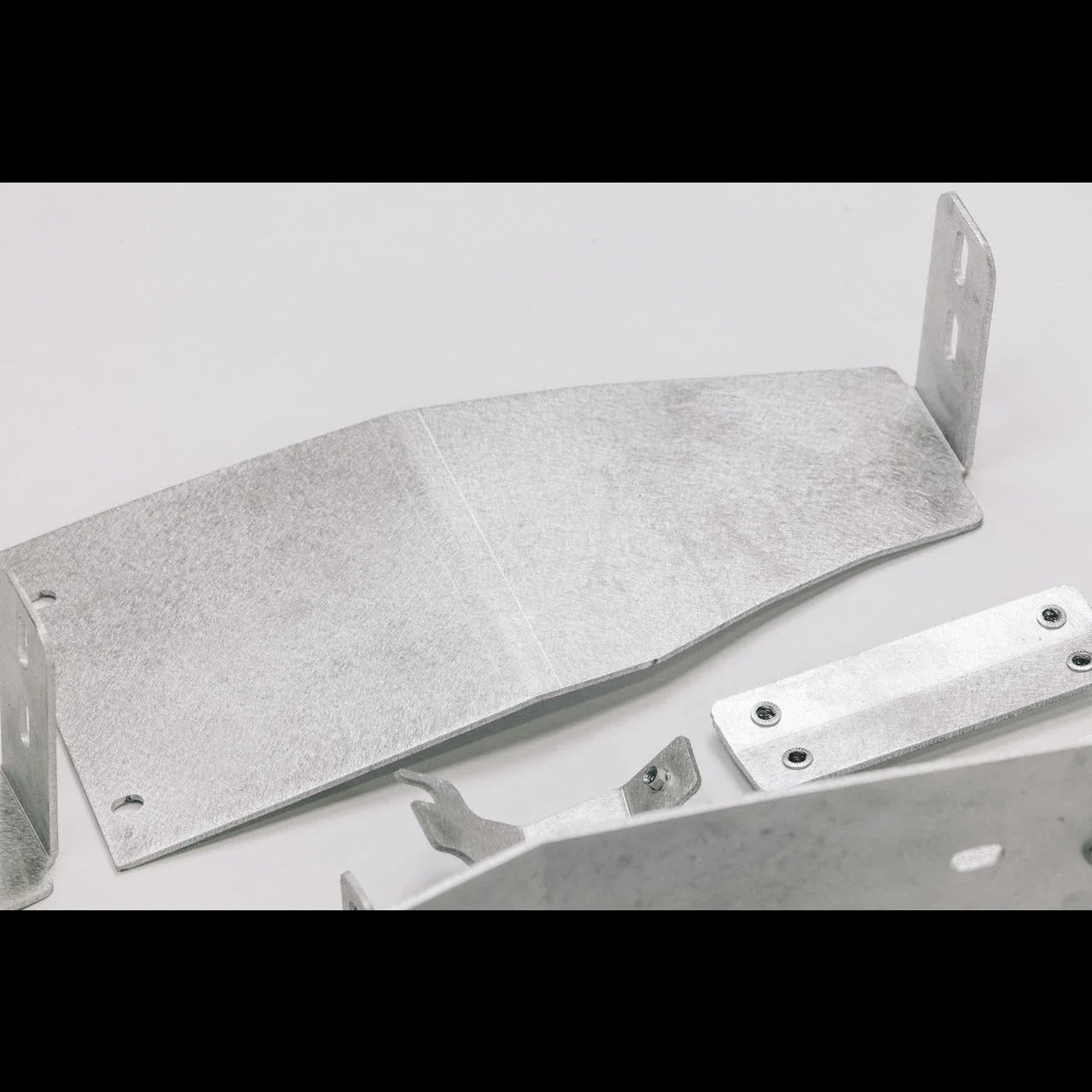 Silver metal skid plate with mounting brackets for off-road vehicle protection