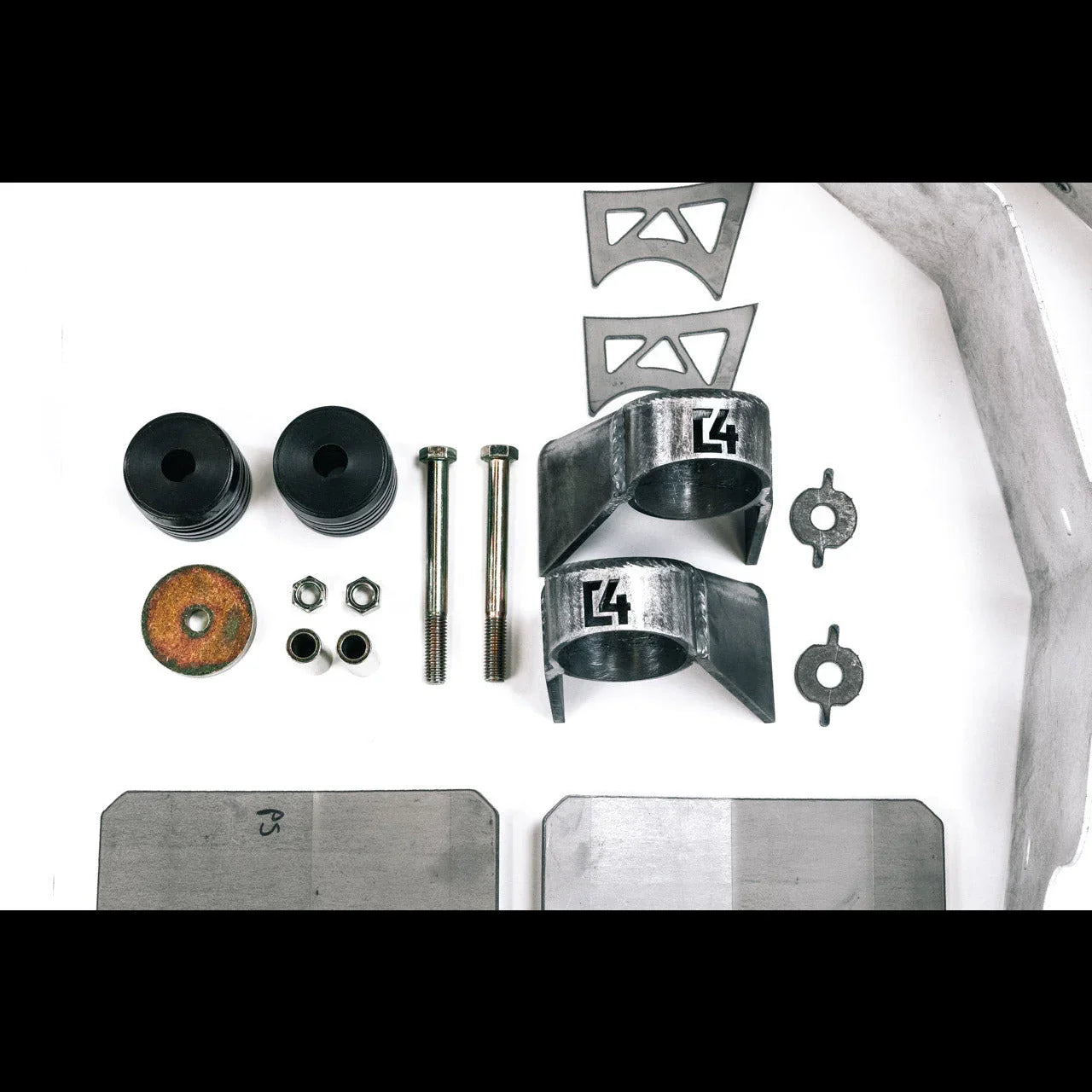 Off-road vehicle suspension lift kit hardware with brackets, bolts, and bushings on white background