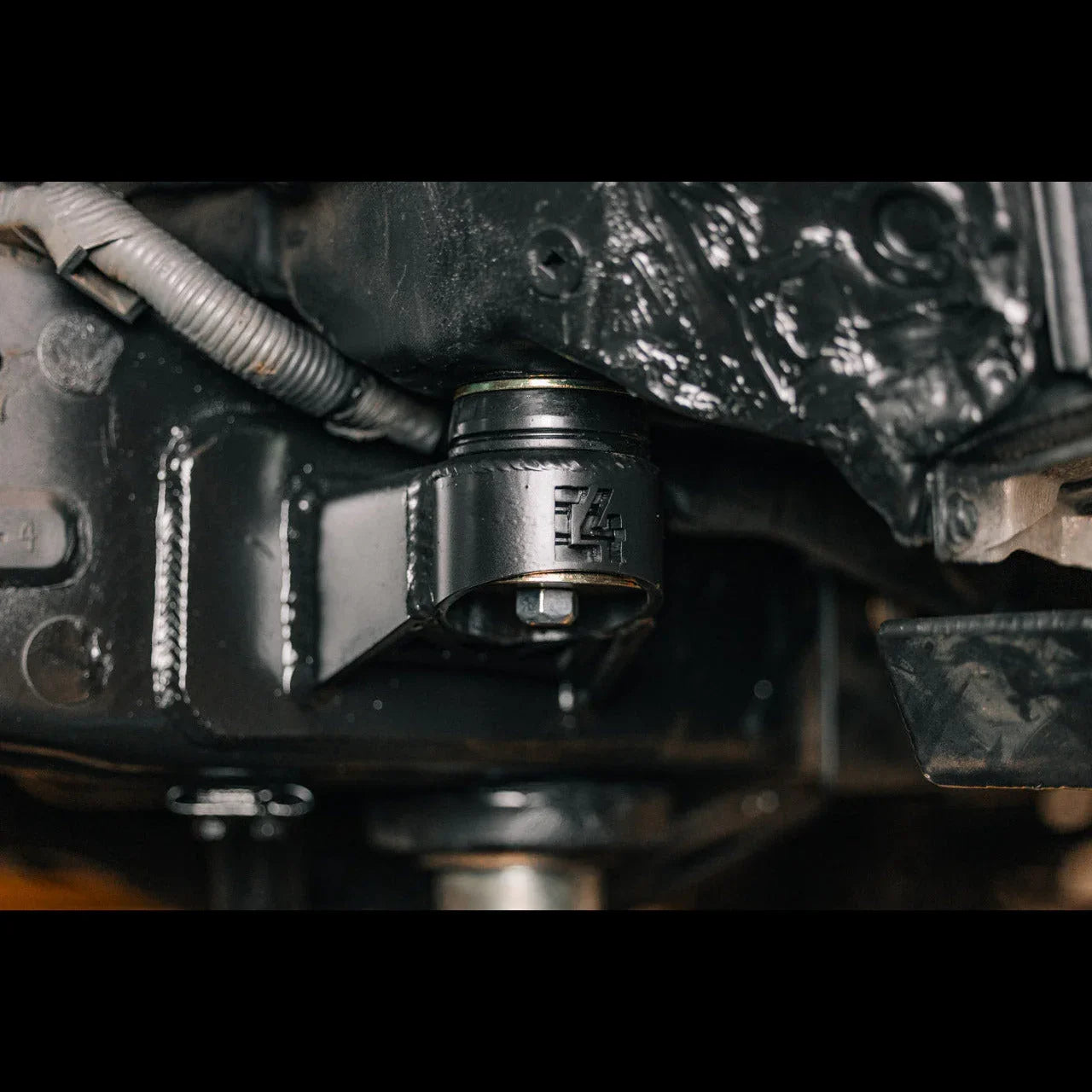 Close-up of aftermarket suspension bushing installed on off-road vehicle chassis