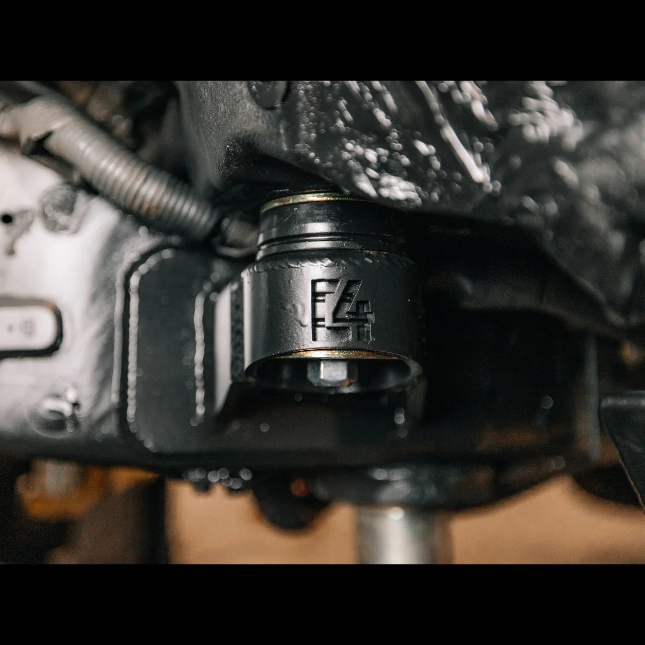 Close-up of heavy-duty black suspension bushing mount on off-road vehicle undercarriage