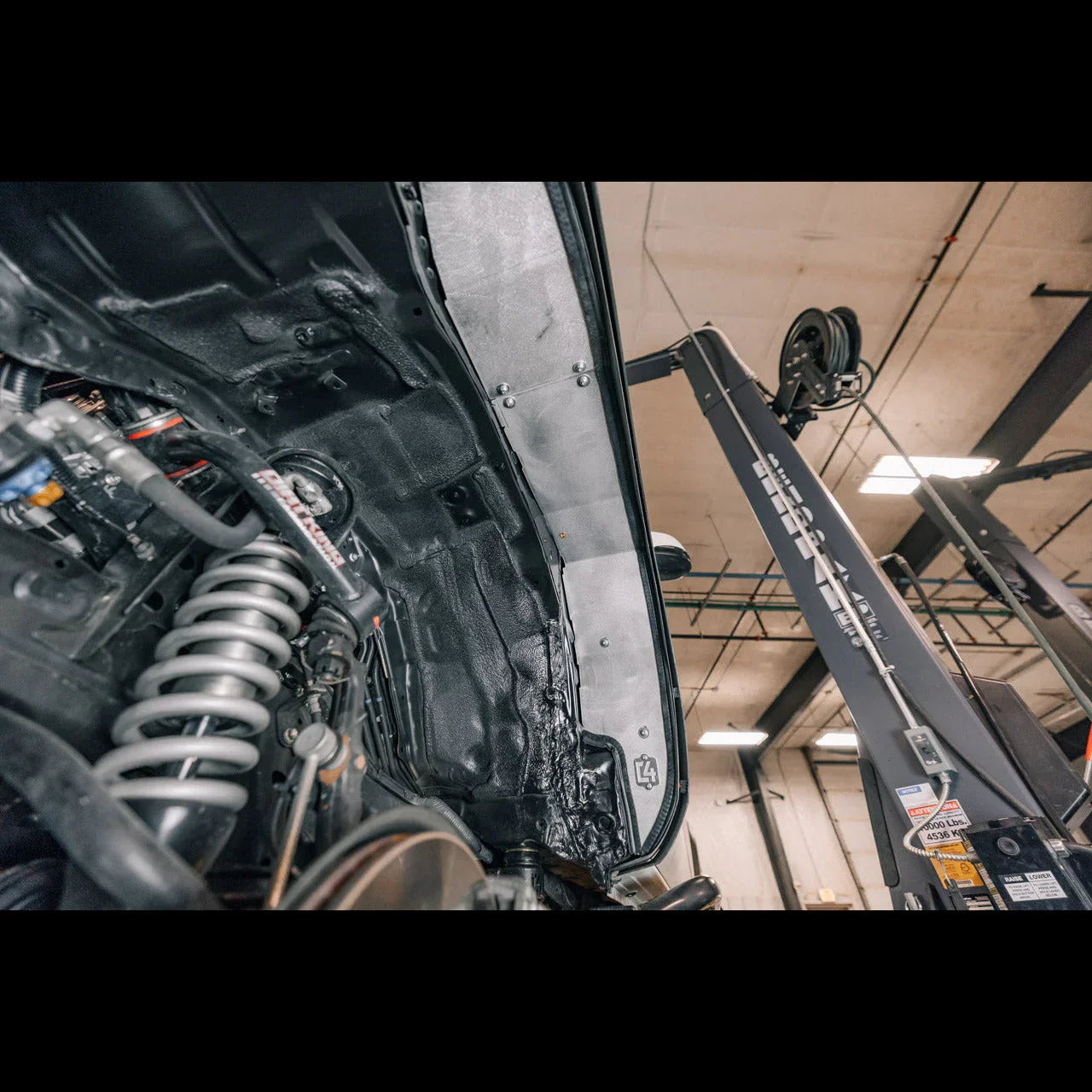 Close-up of Toyota off-road vehicle suspension and inner fender in a garage