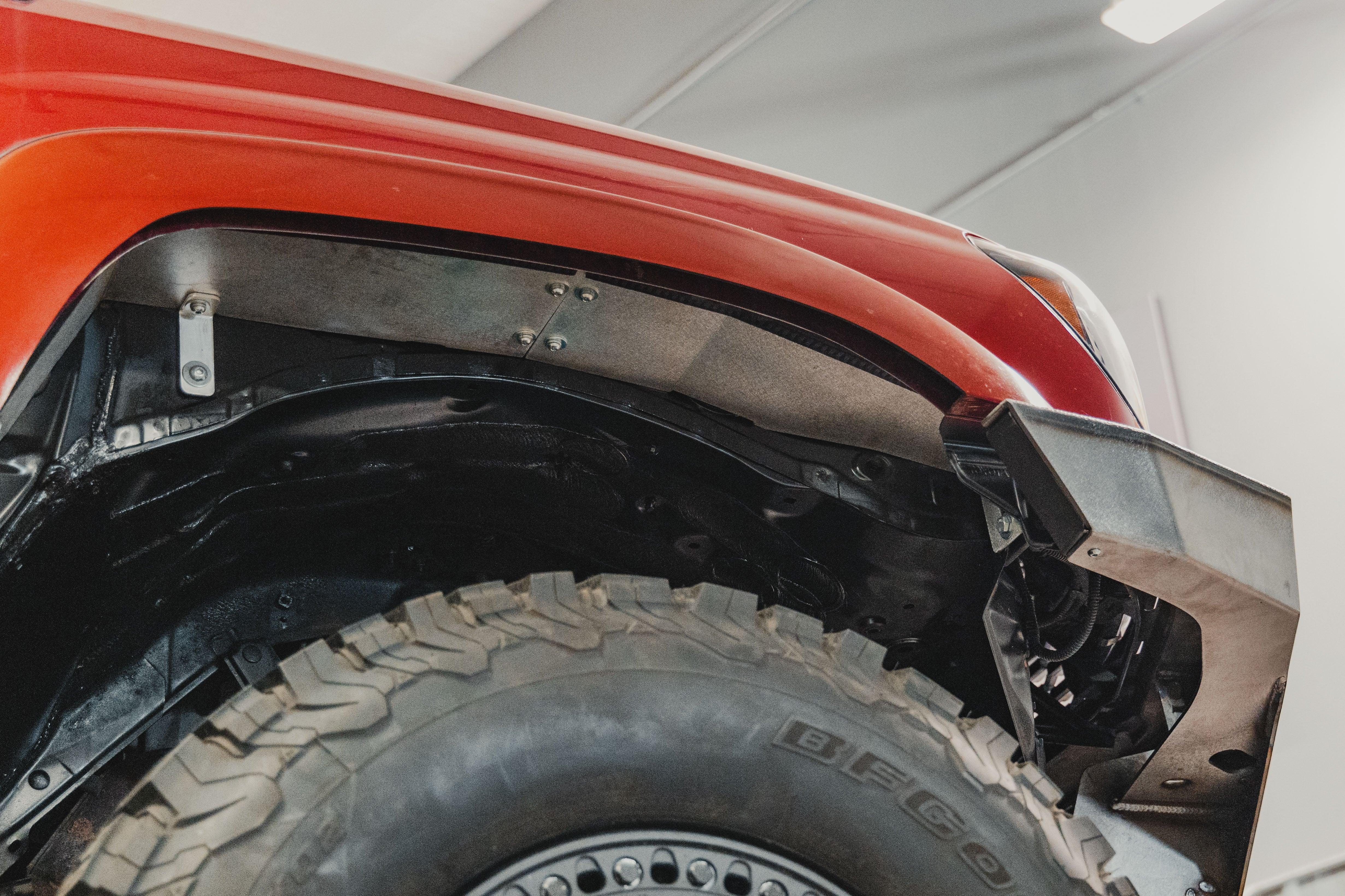 Close-up of aftermarket front fender liner and off-road tire on Toyota Tacoma