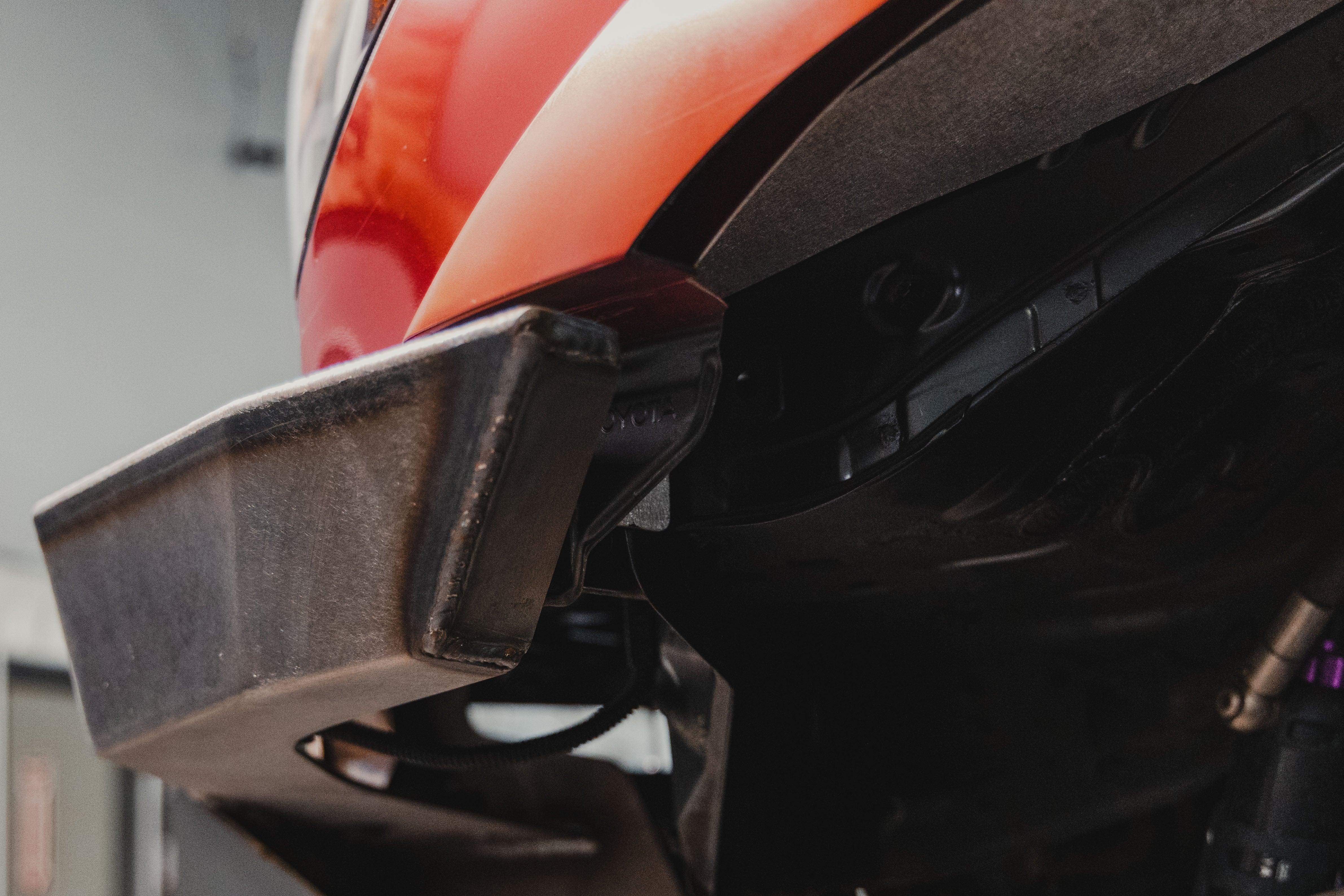 Steel aftermarket front bumper installed on a red Toyota truck for off-road protection