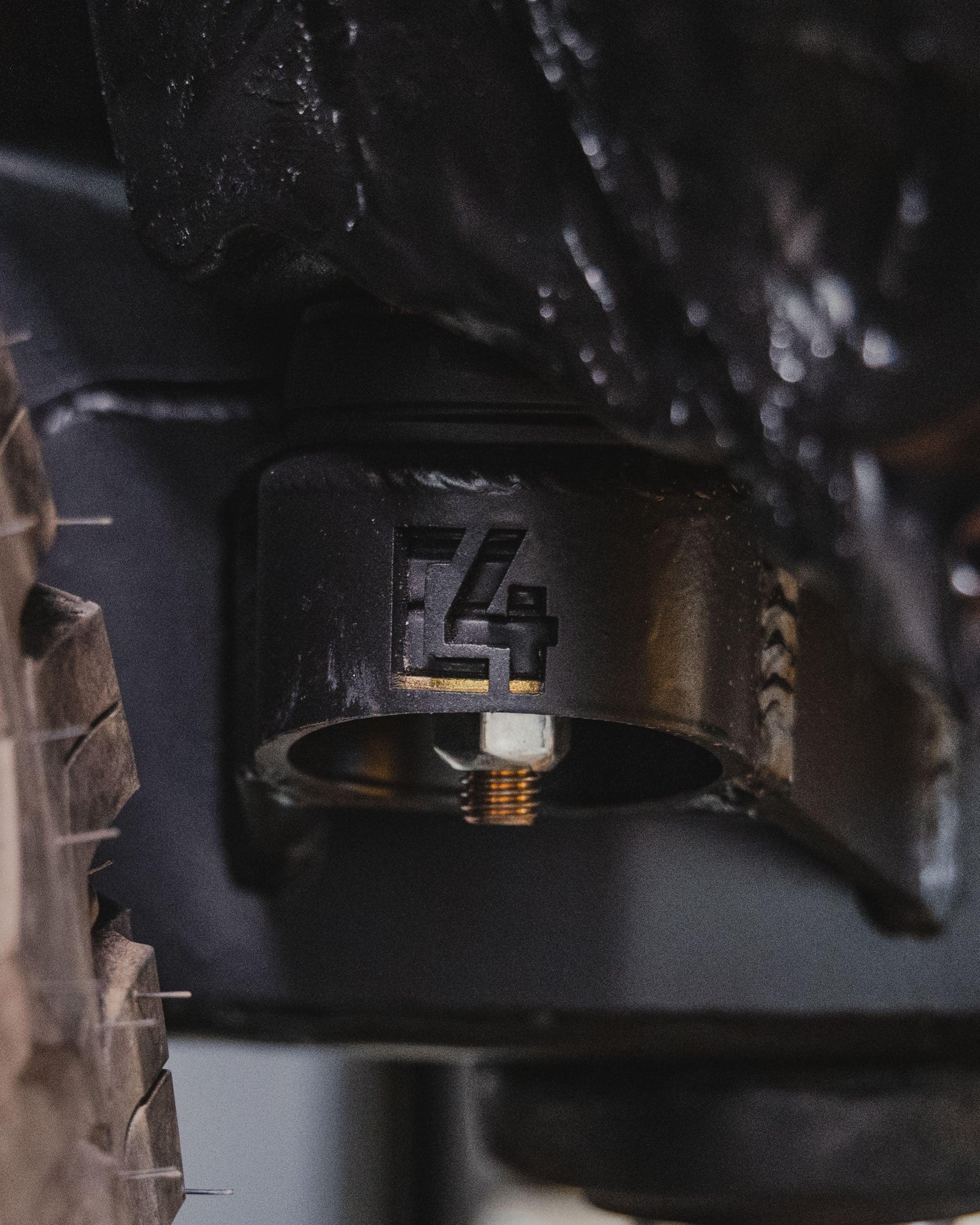 Close-up of off-road vehicle suspension component with bolt and metal bracket.