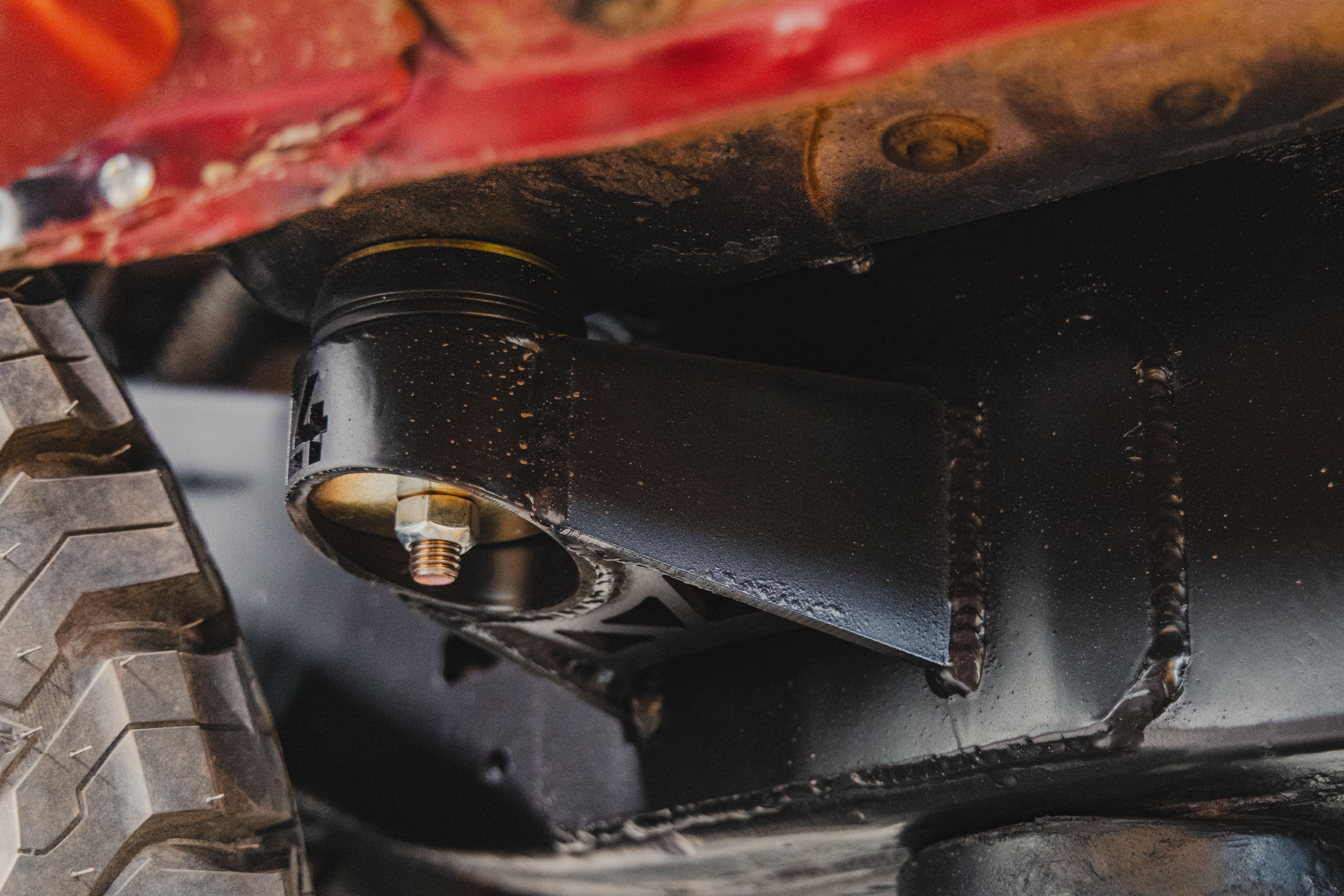 Close-up of off-road vehicle suspension component and tire for overlanding upgrades.
