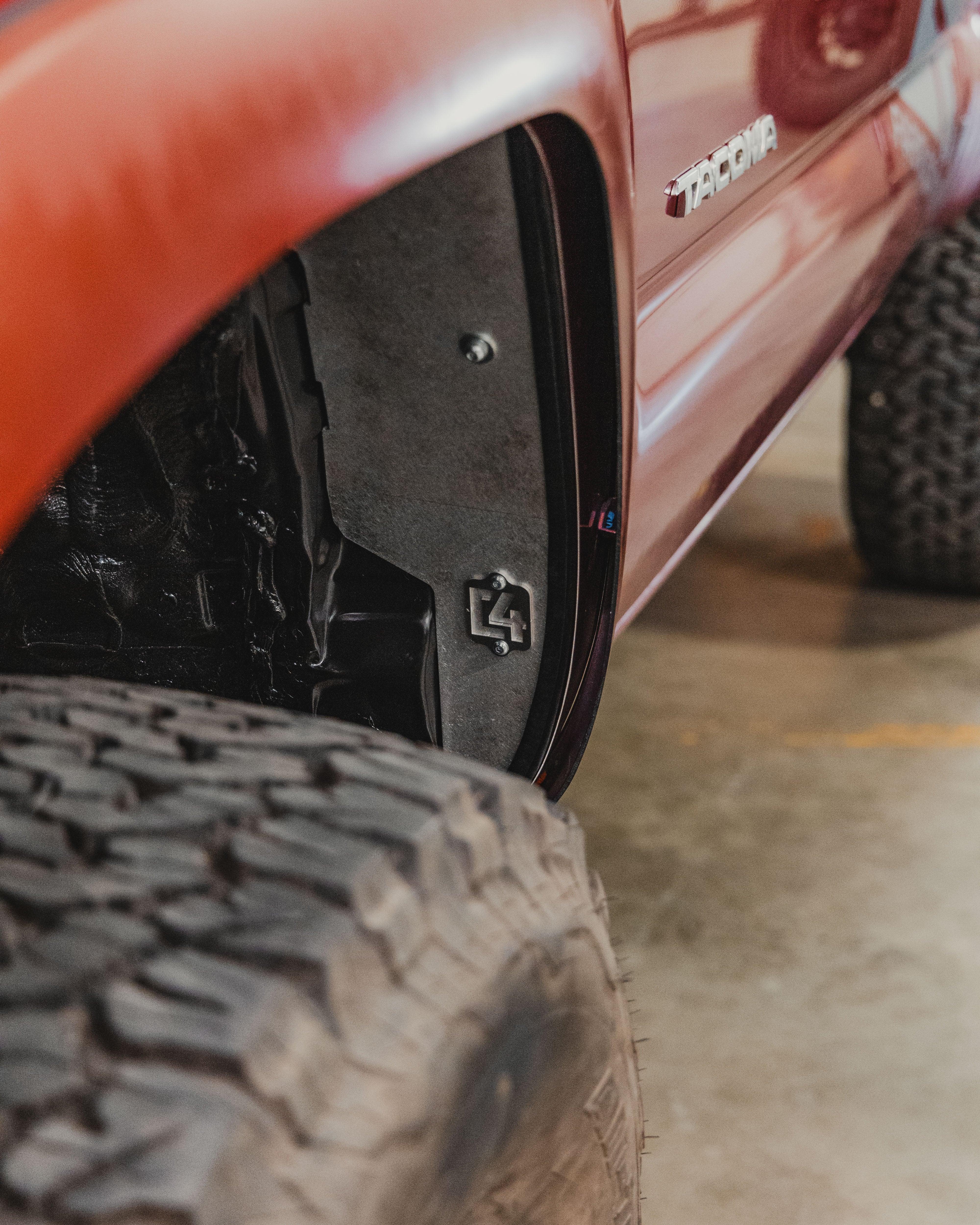 Toyota Tacoma red fender with aftermarket wheel well liner and off-road tire
