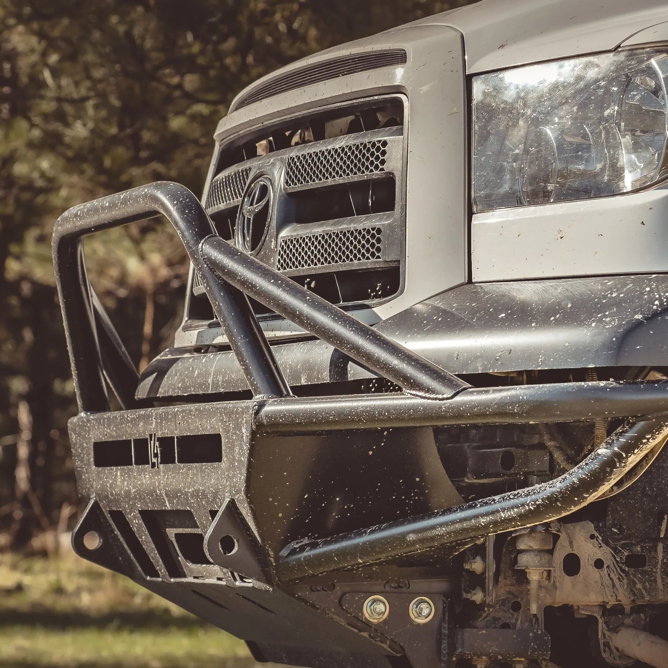 Toyota truck with aftermarket off-road steel front bumper, close-up outdoors
