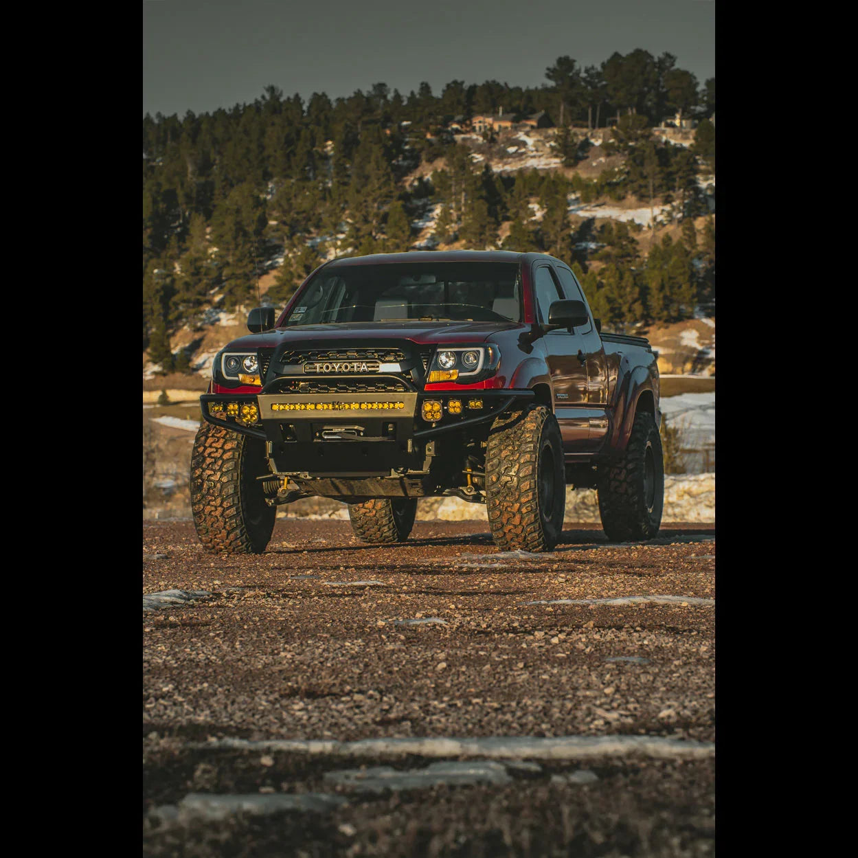 Lifted Toyota Tacoma with off-road bumper and LED lights parked on rocky terrain