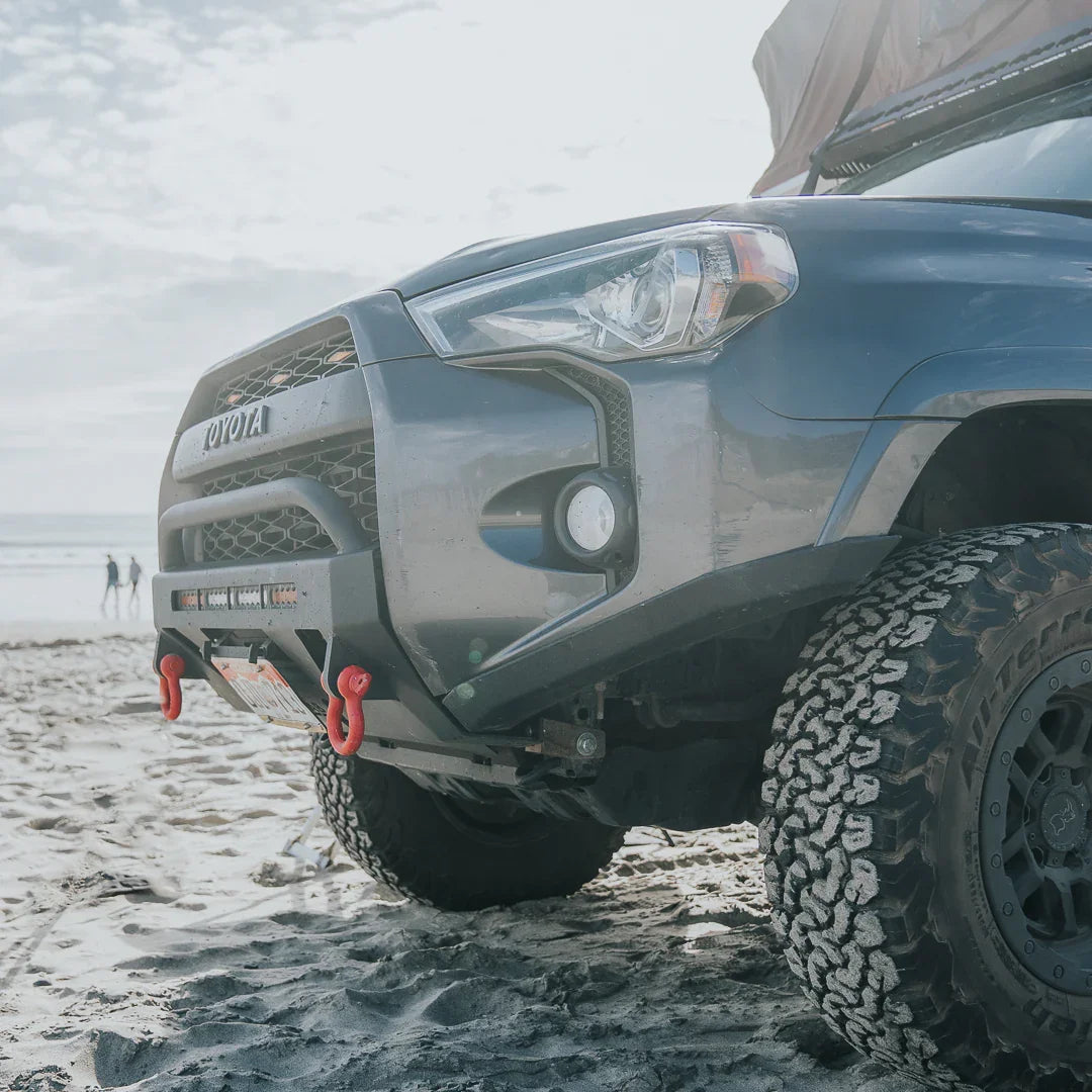 Toyota 4Runner with high clearance off-road bumper and recovery hooks on a sandy beach