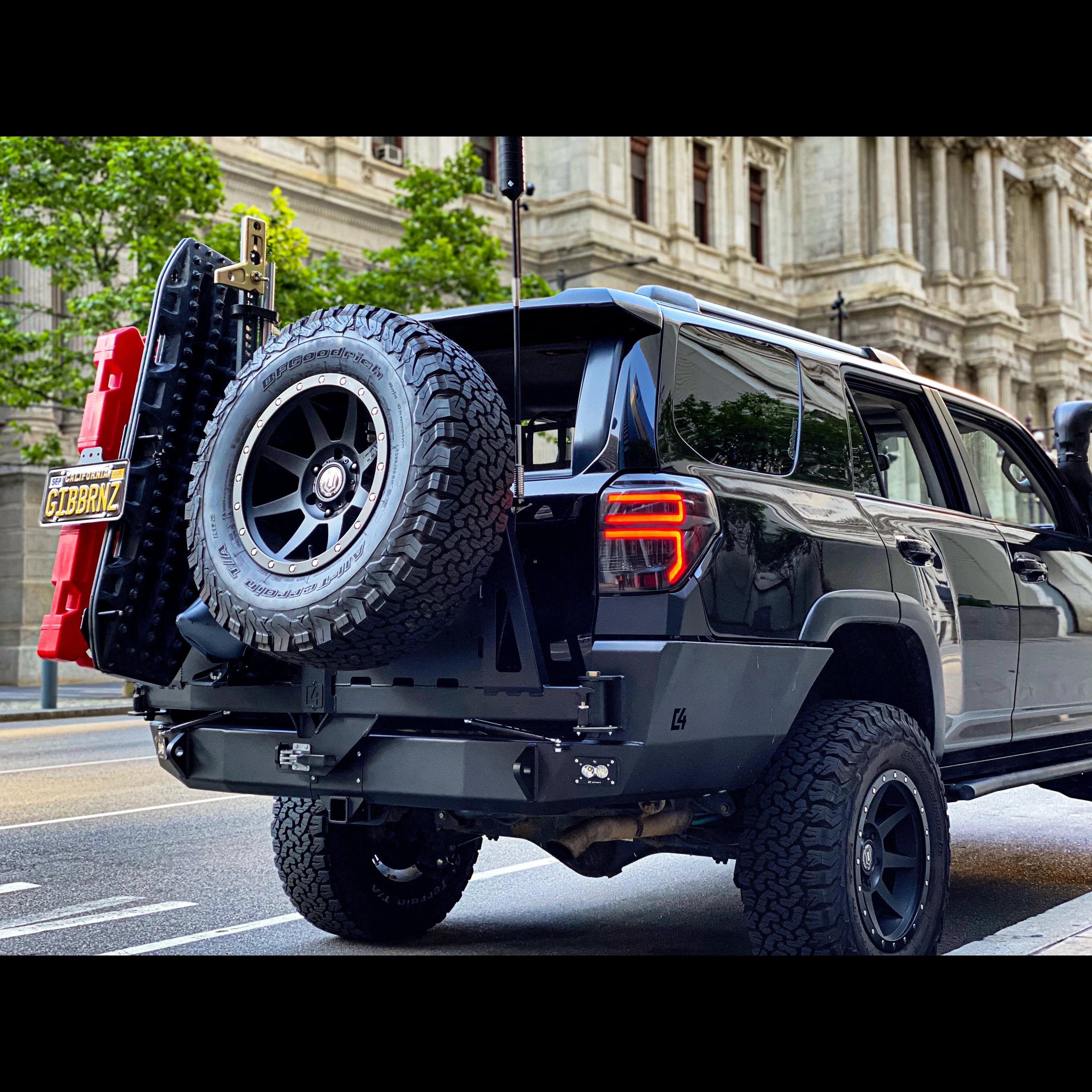 Toyota 4Runner with overland rear bumper, spare tire, recovery boards, and fuel canister.