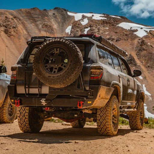 Toyota 4Runner with overland rear bumper and spare tire, off-road in mountain terrain