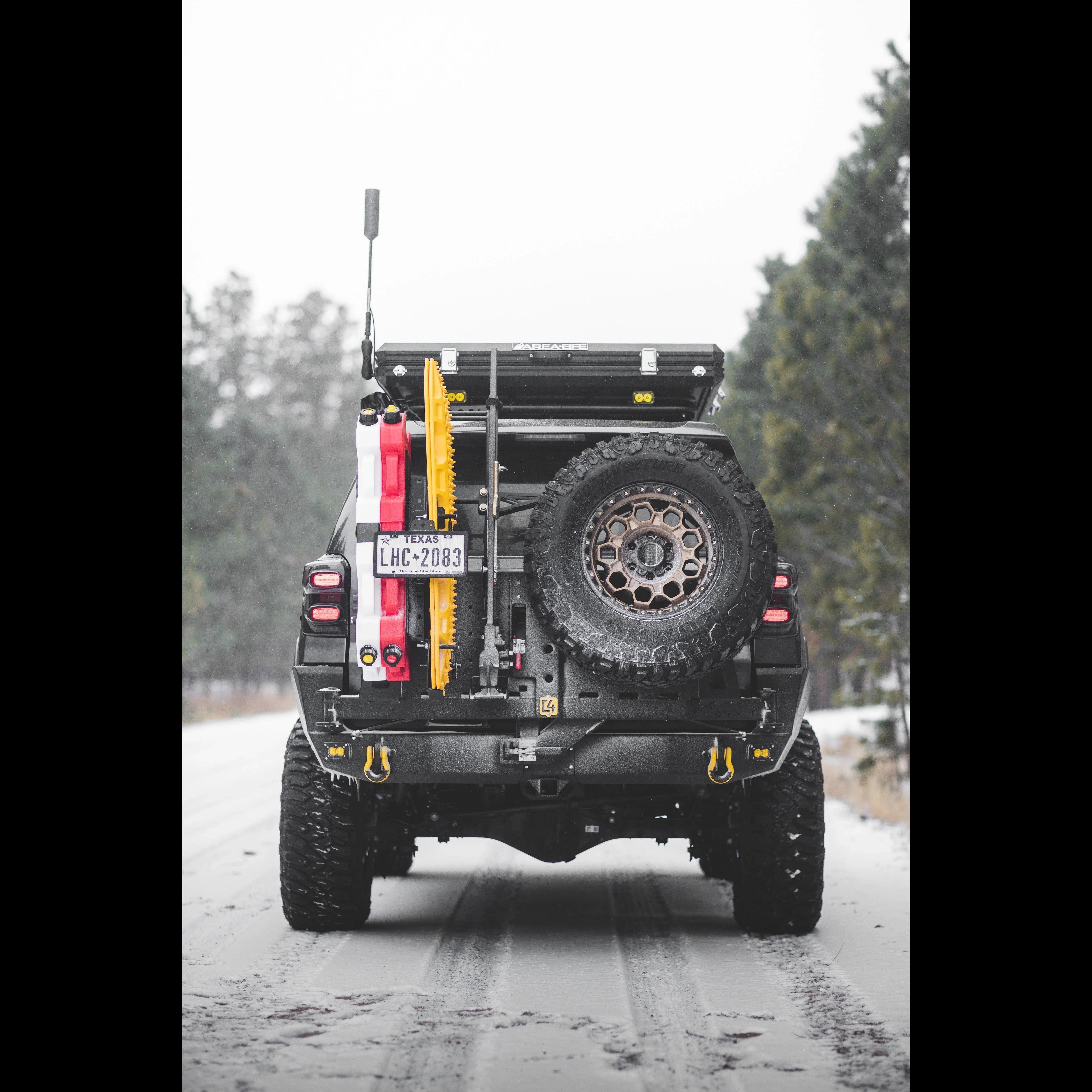 Toyota 4Runner with overland rear bumper, spare tire, recovery gear, parked on snowy road