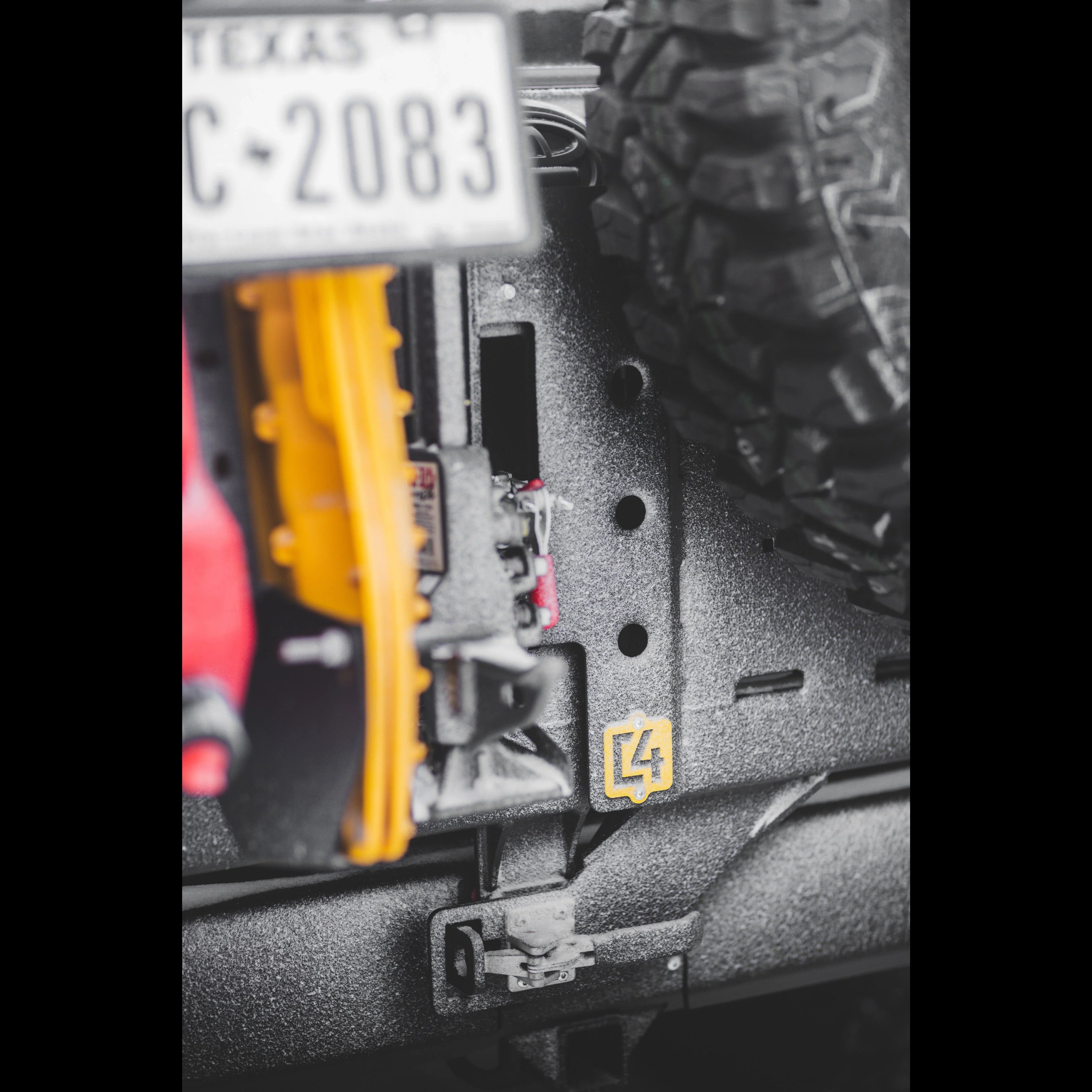 Closeup of Toyota 4Runner overland rear bumper with mounted spare tire and recovery gear.