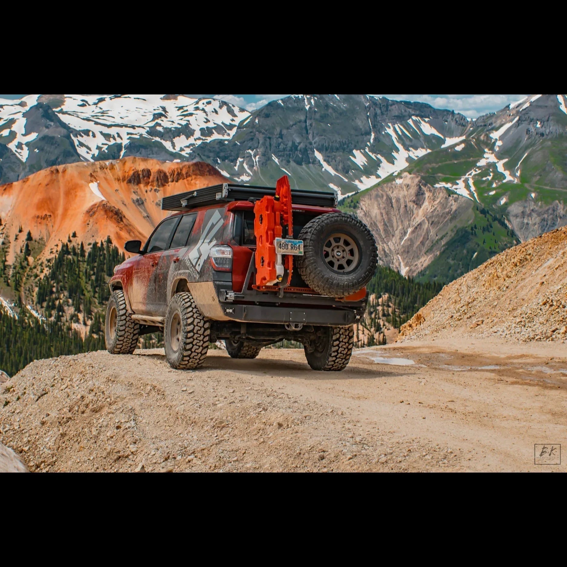 Toyota 4Runner with overland rear bumper, spare tire, and recovery gear on a mountain trail