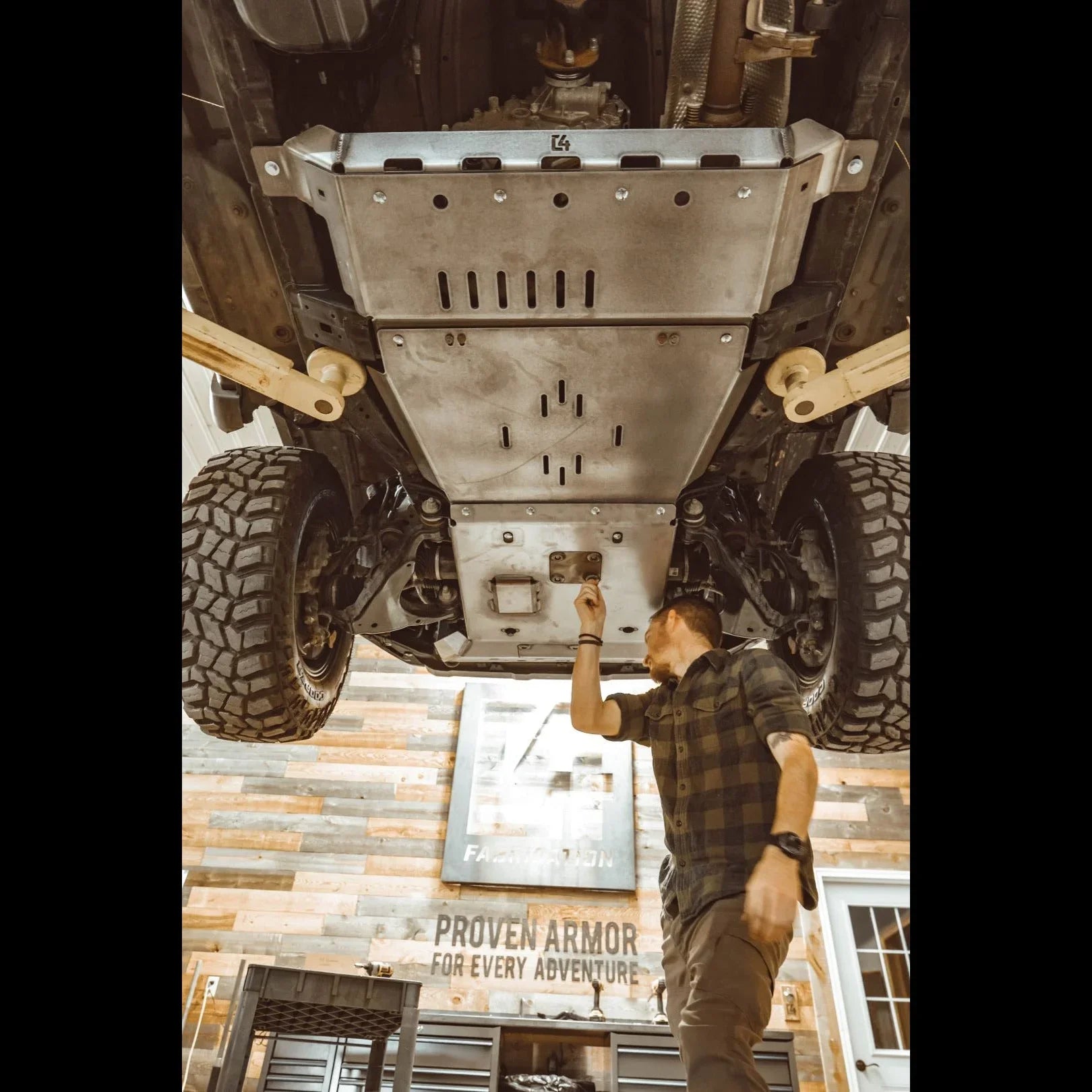 Mechanic installing rear skid plates on Toyota 4Runner 5th Gen in a garage