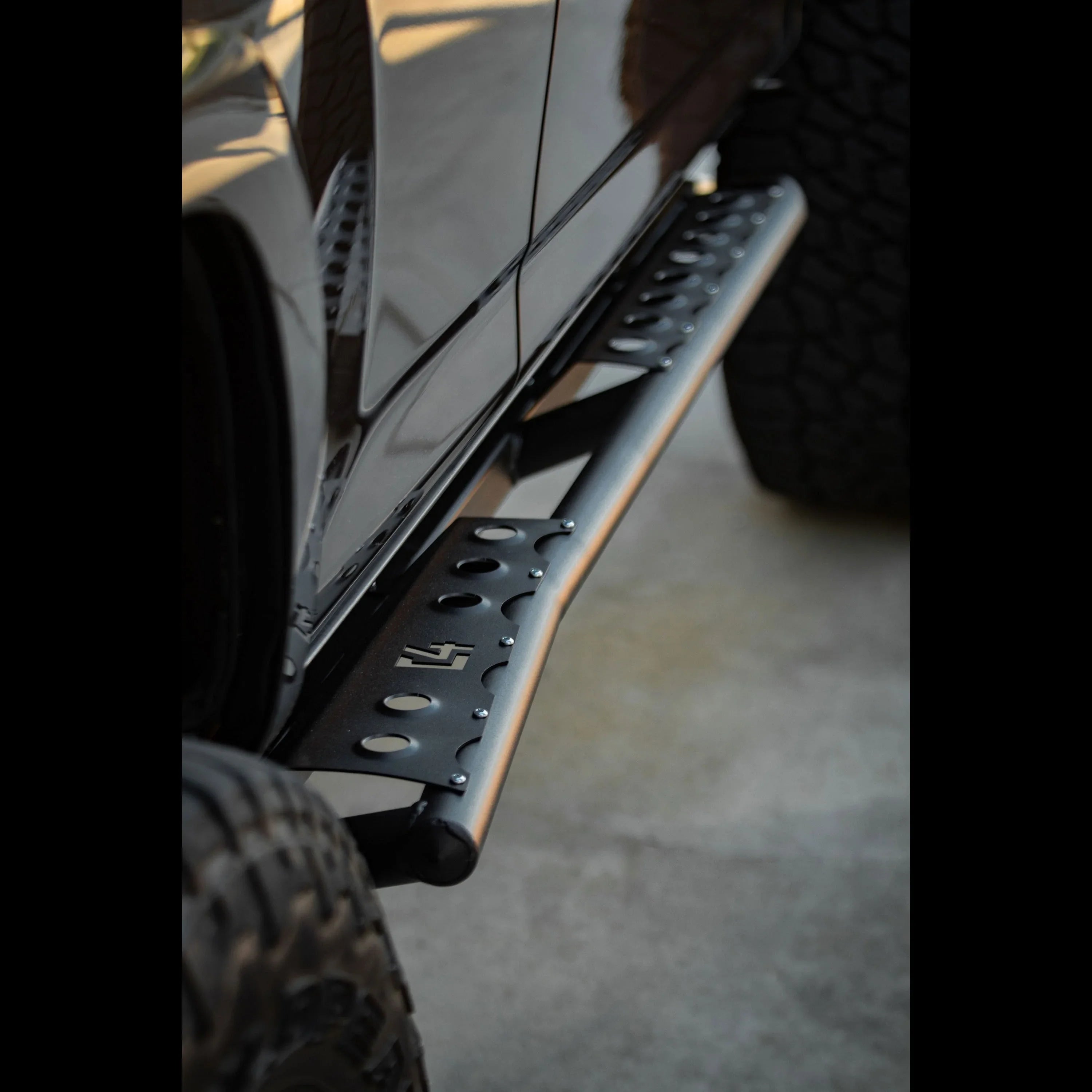Close-up of black rock slider installed on Toyota 4Runner, off-road accessory detail