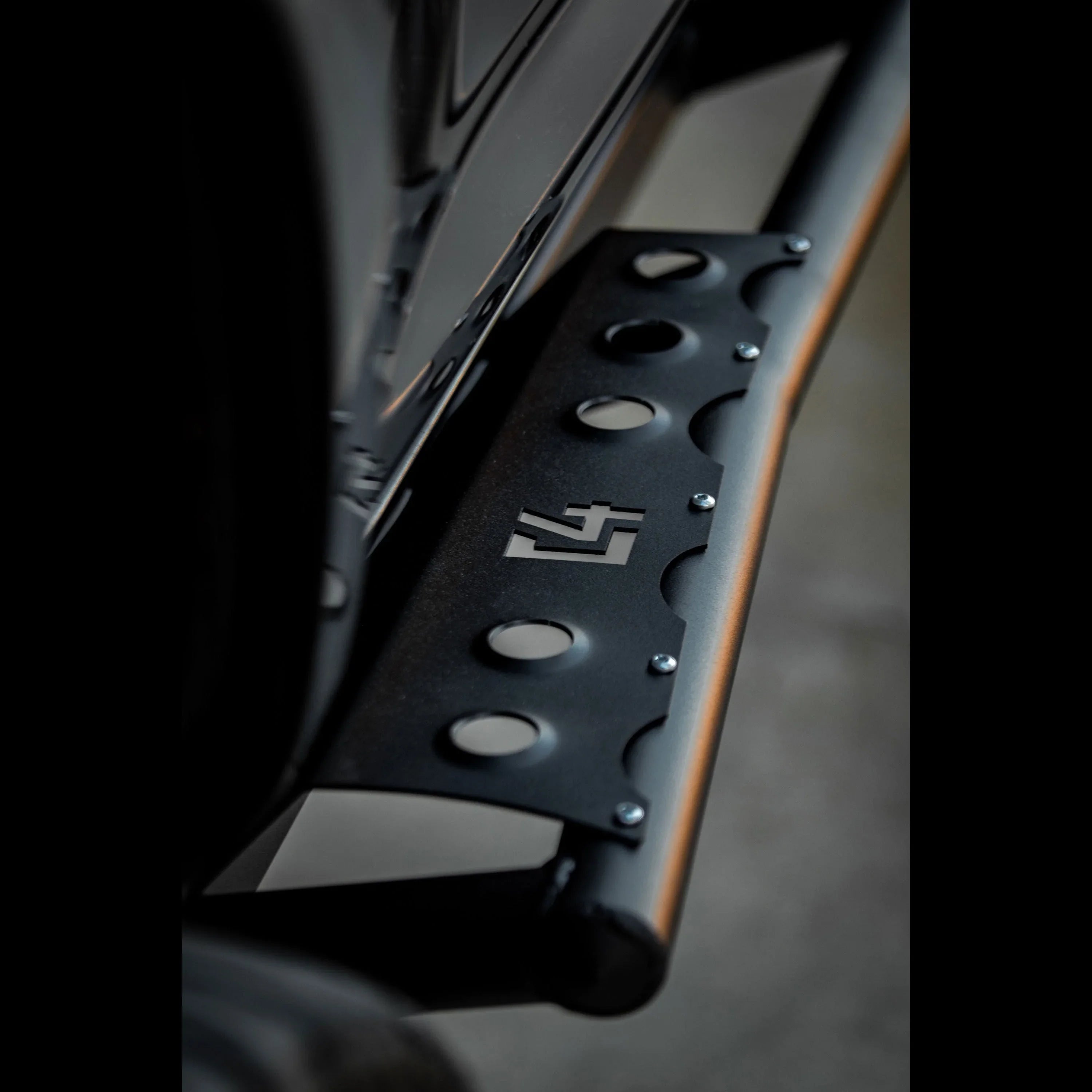 Close-up of black metal 4Runner rock slider with cutouts, mounted on vehicle side.