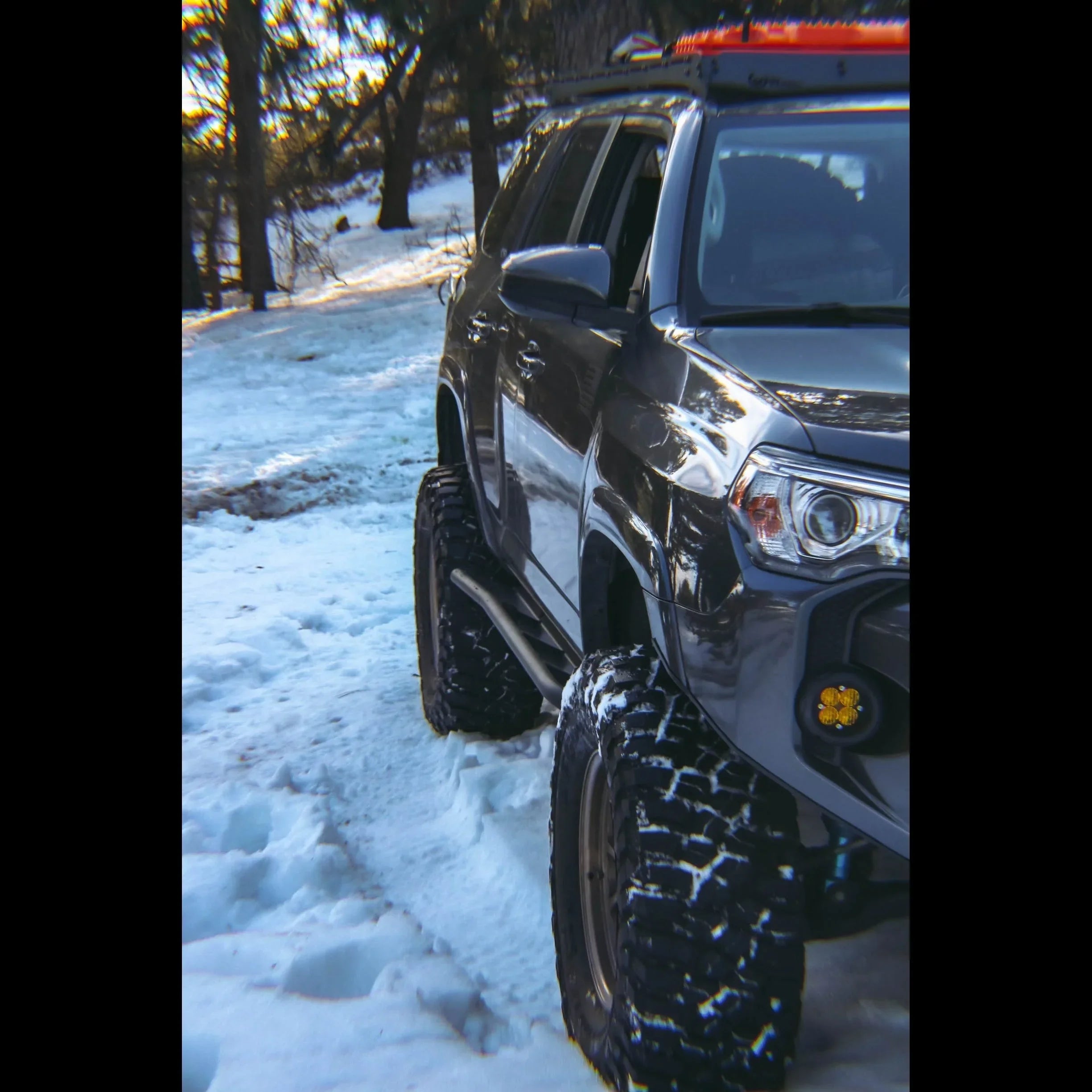 Toyota 4Runner 5th Gen with rock sliders and off-road tires parked on snowy trail