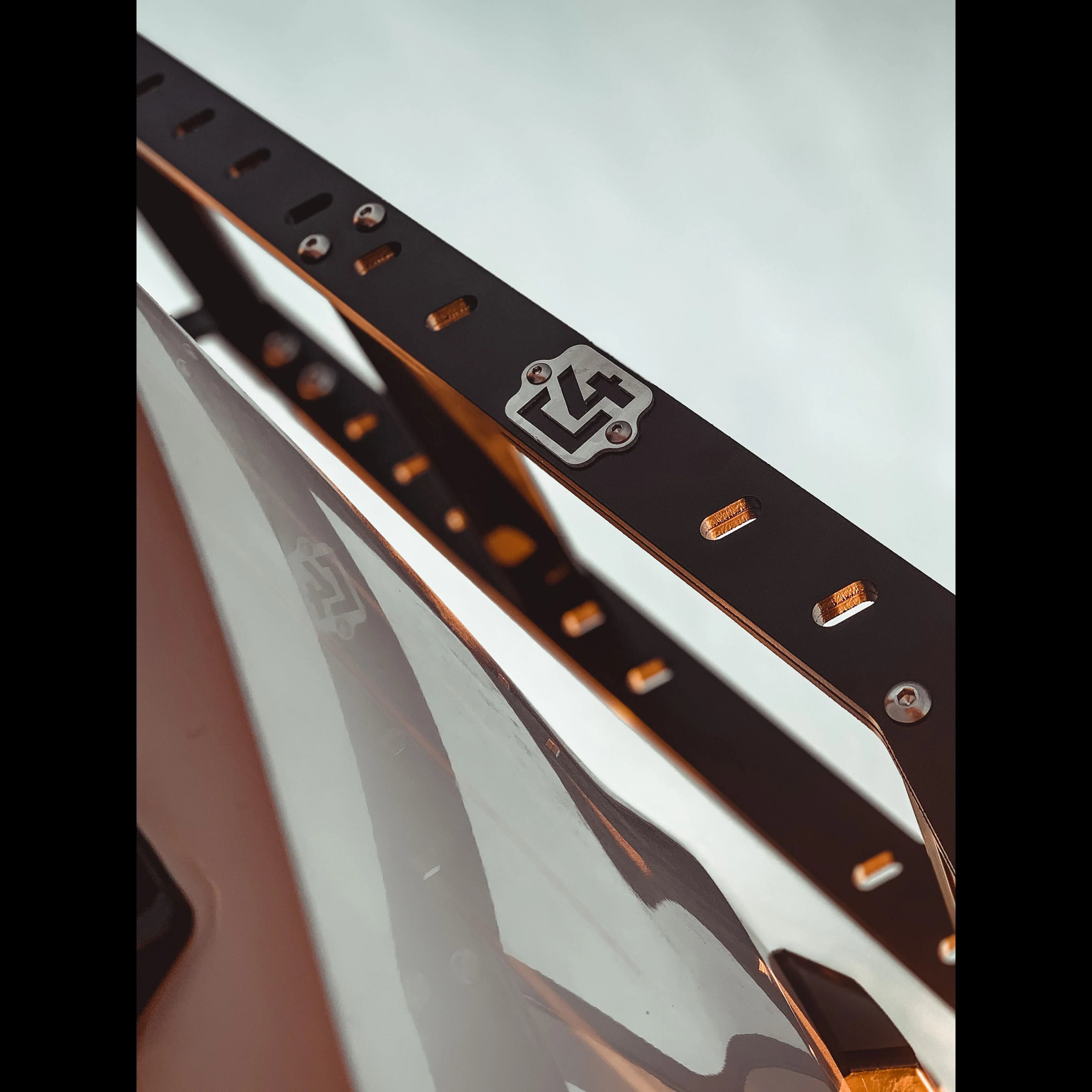 Close-up of black hatch ladder installed on Toyota 4Runner, showing metal badge and hardware