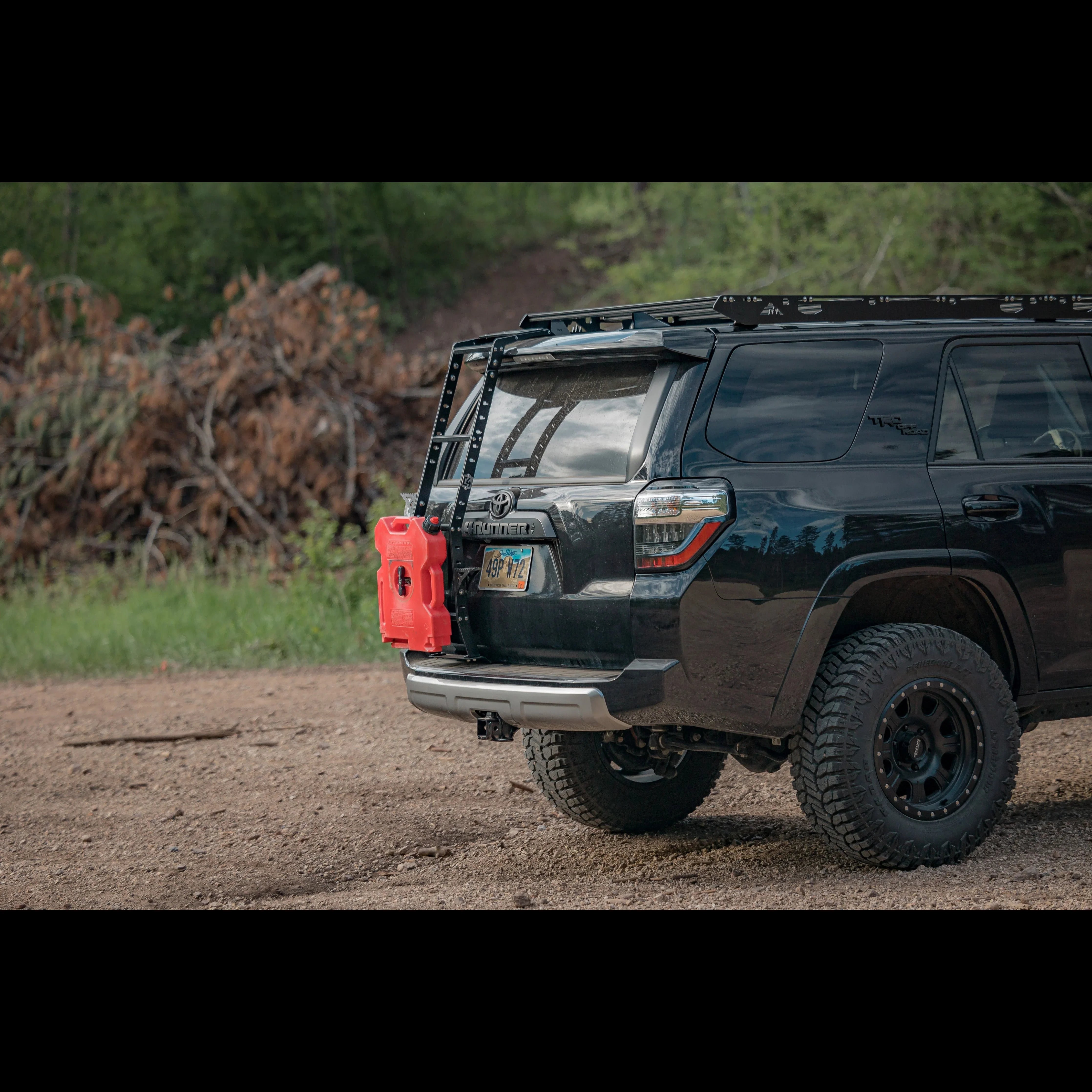 Toyota 4Runner with summit hatch ladder, roof rack, and fuel container in outdoor setting