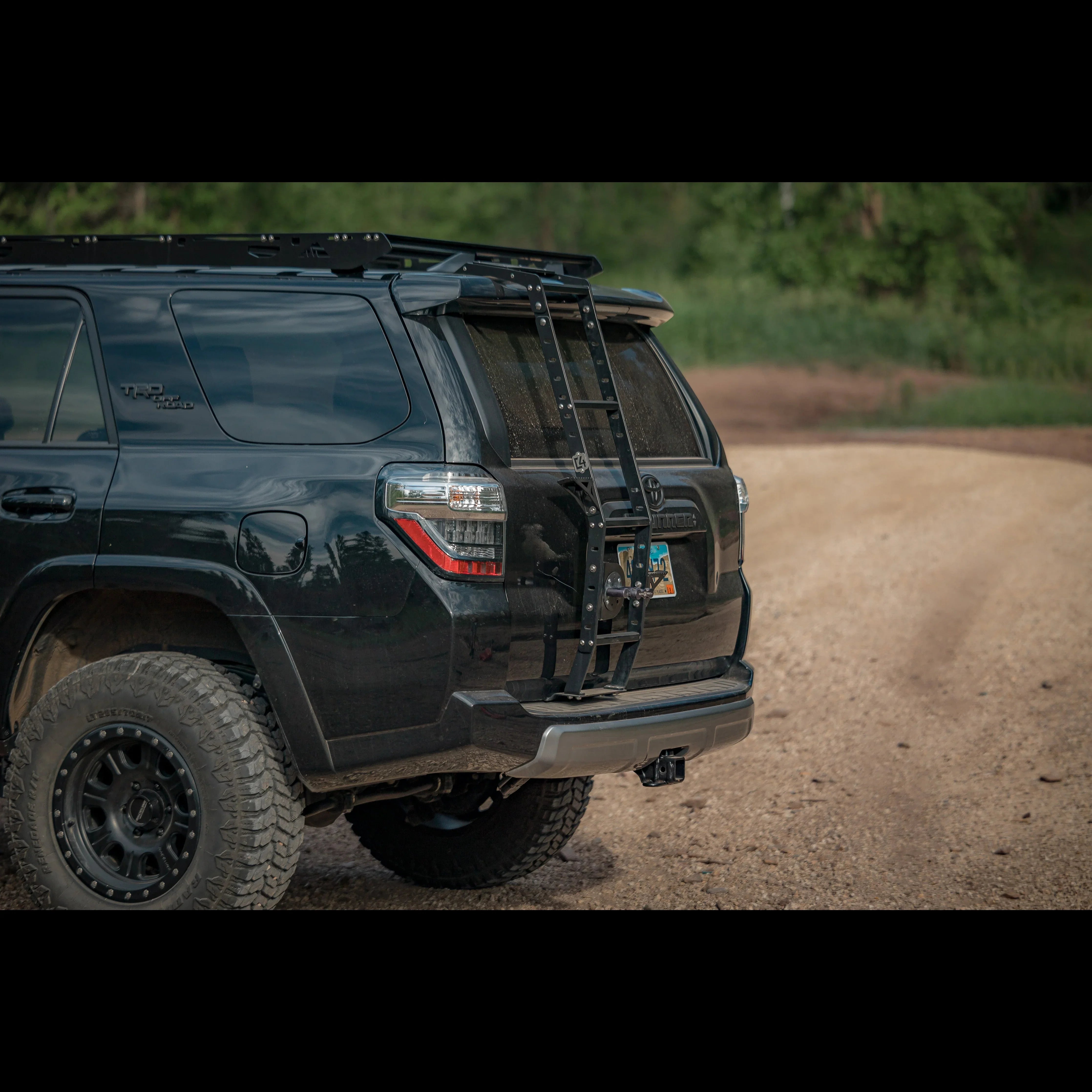 Toyota 4Runner with rear hatch ladder and off-road accessories on dirt road