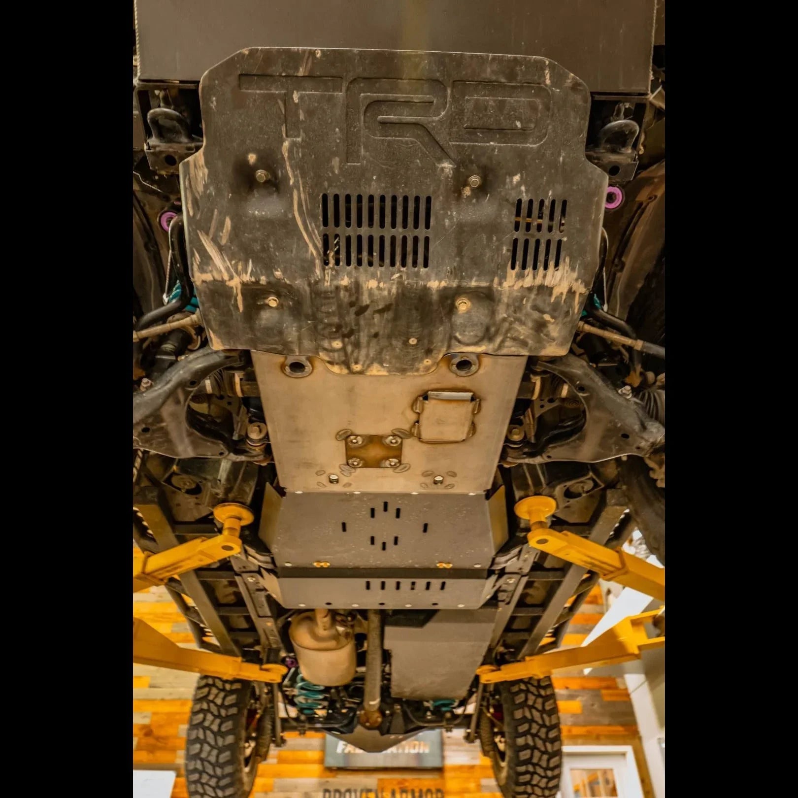 Toyota 4Runner TRD Pro skid plate installed under vehicle on lift, showing off-road protection.