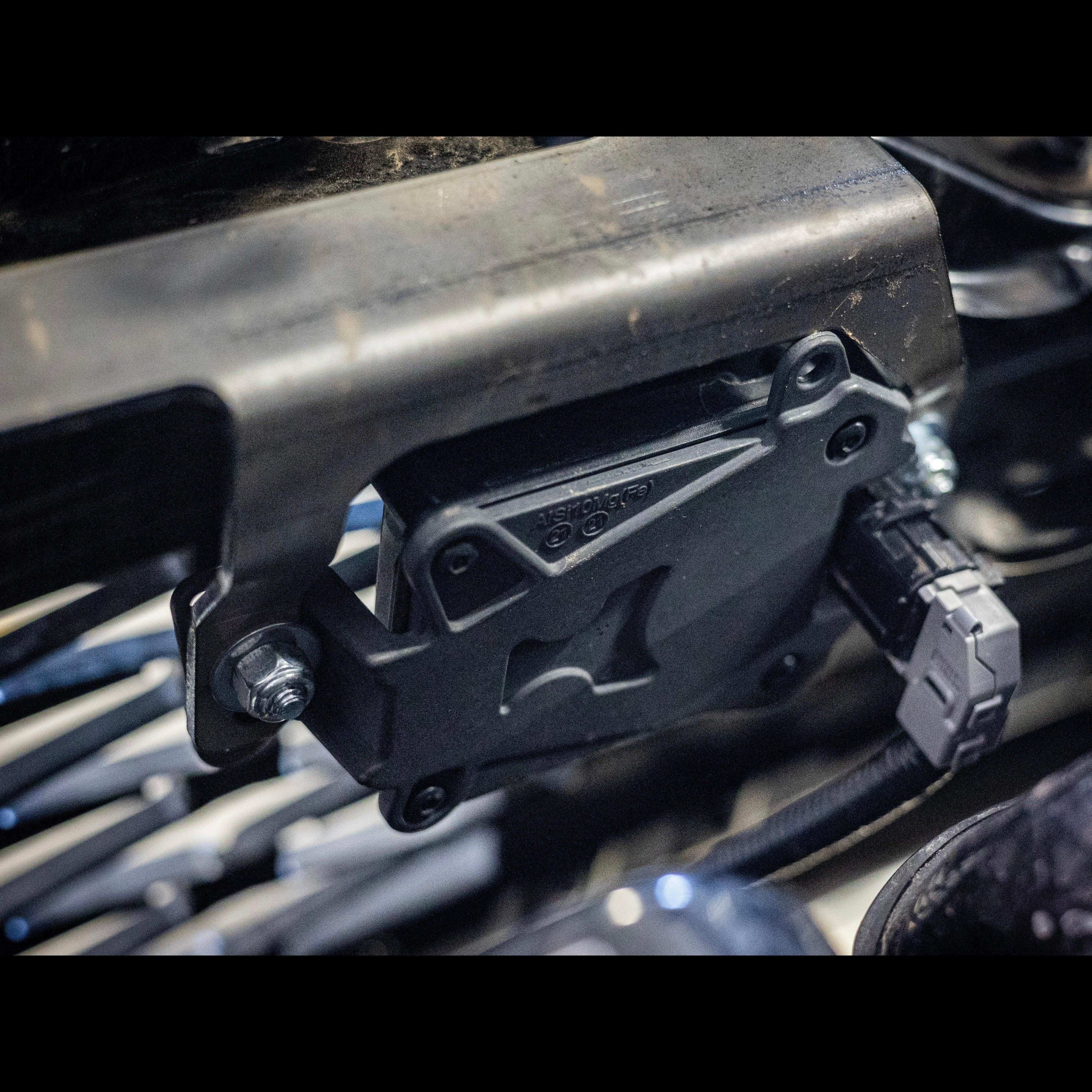 Toyota 4Runner TSS relocation kit installed on front bumper with wiring connector visible