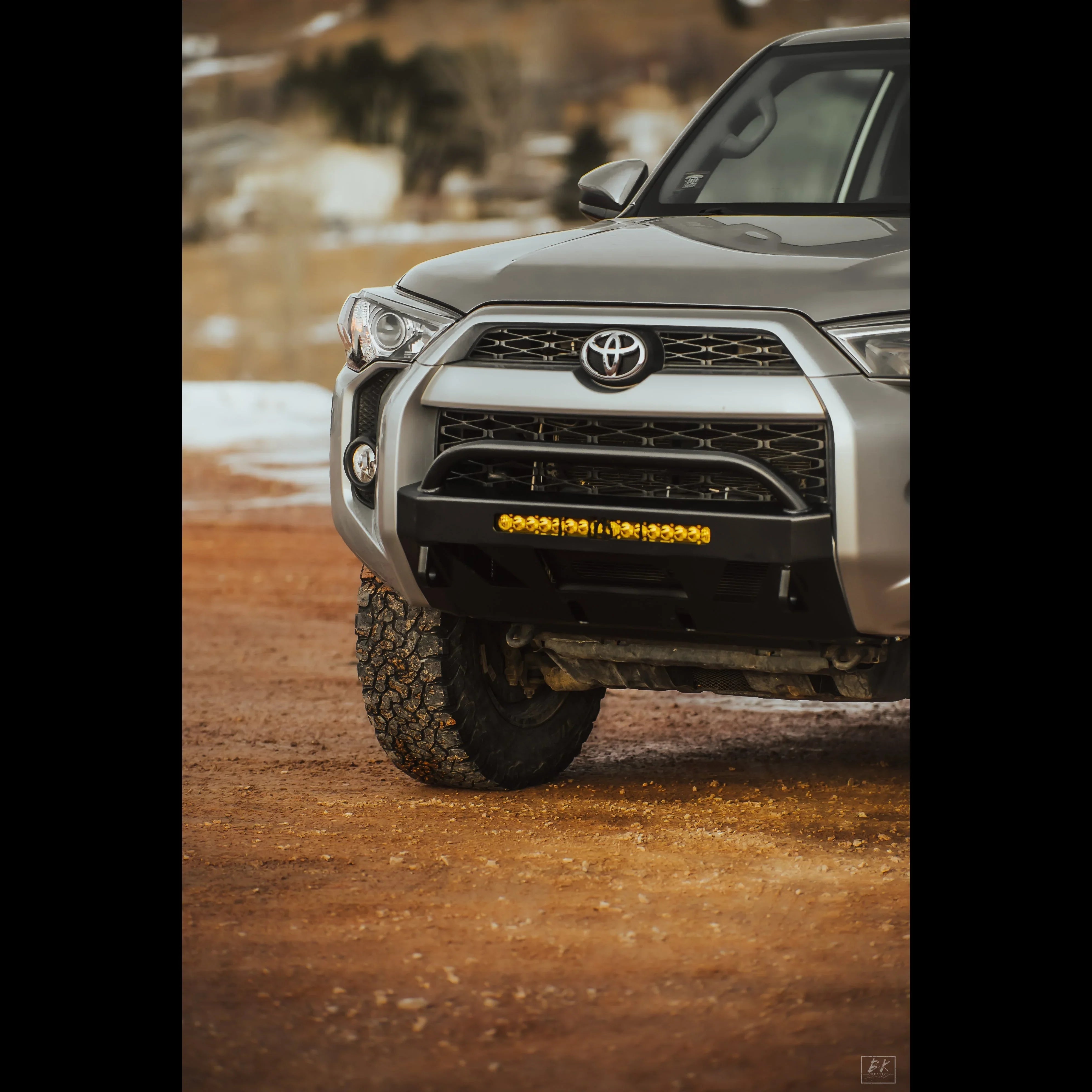 Toyota 4Runner with off-road bumper and LED light bar on rugged dirt terrain