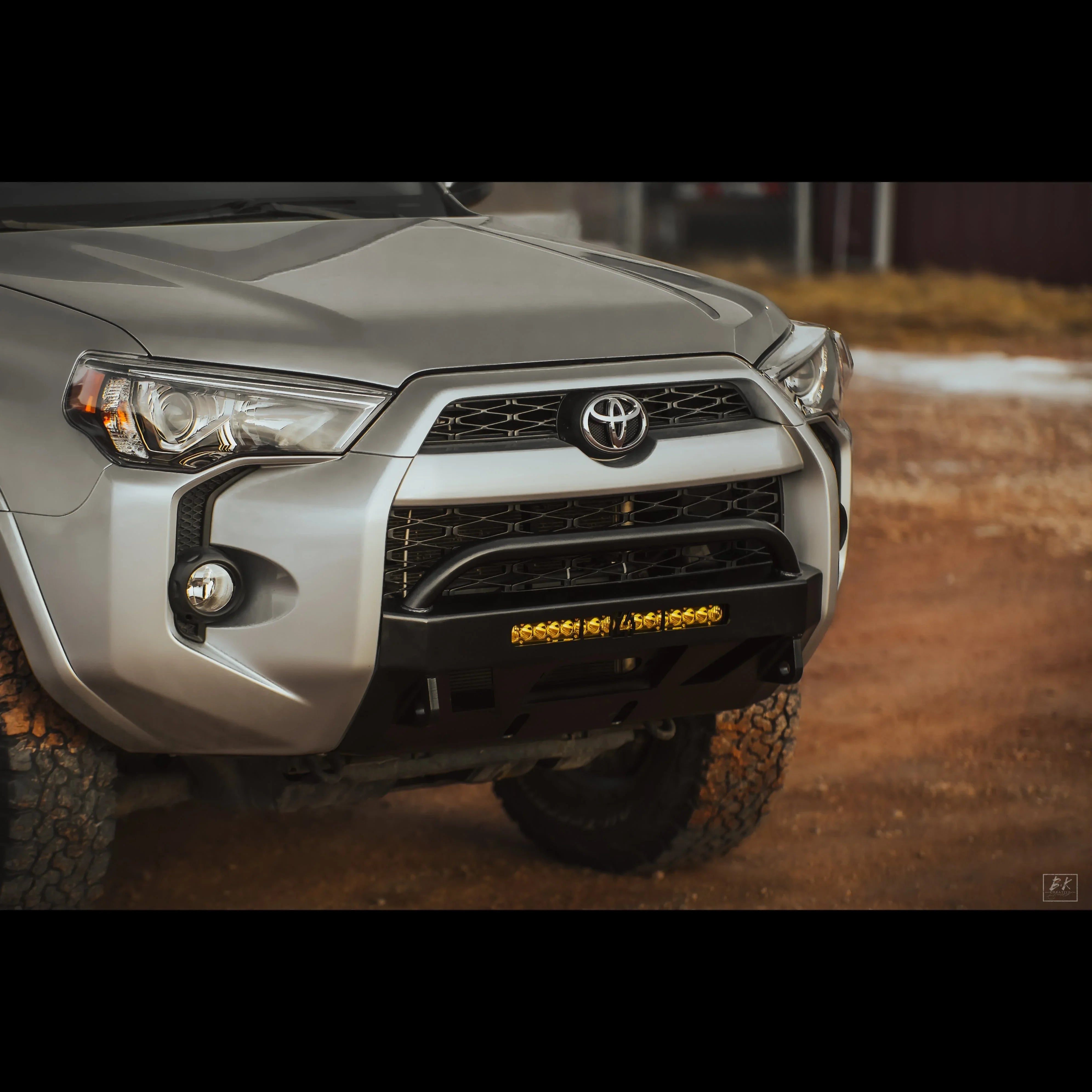 Toyota 4Runner with off-road steel front bumper and LED light bar on rugged terrain