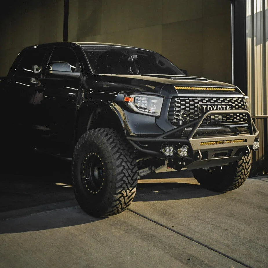 Black Toyota Tundra with off-road bumper, LED light bars, lift kit, and rugged tires
