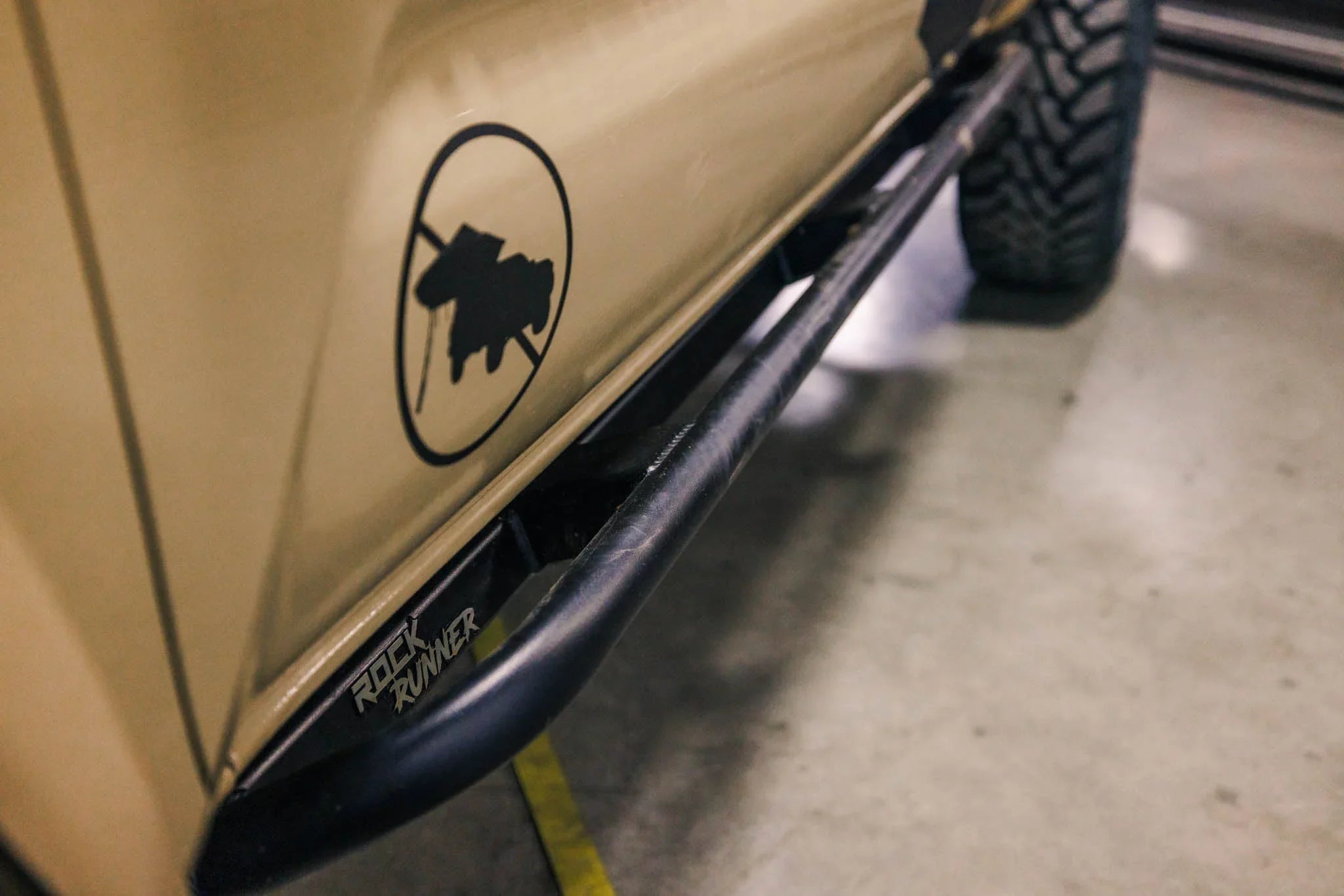 Rock Runner rock slider on beige off-road vehicle with rugged tire, ideal for overlanding