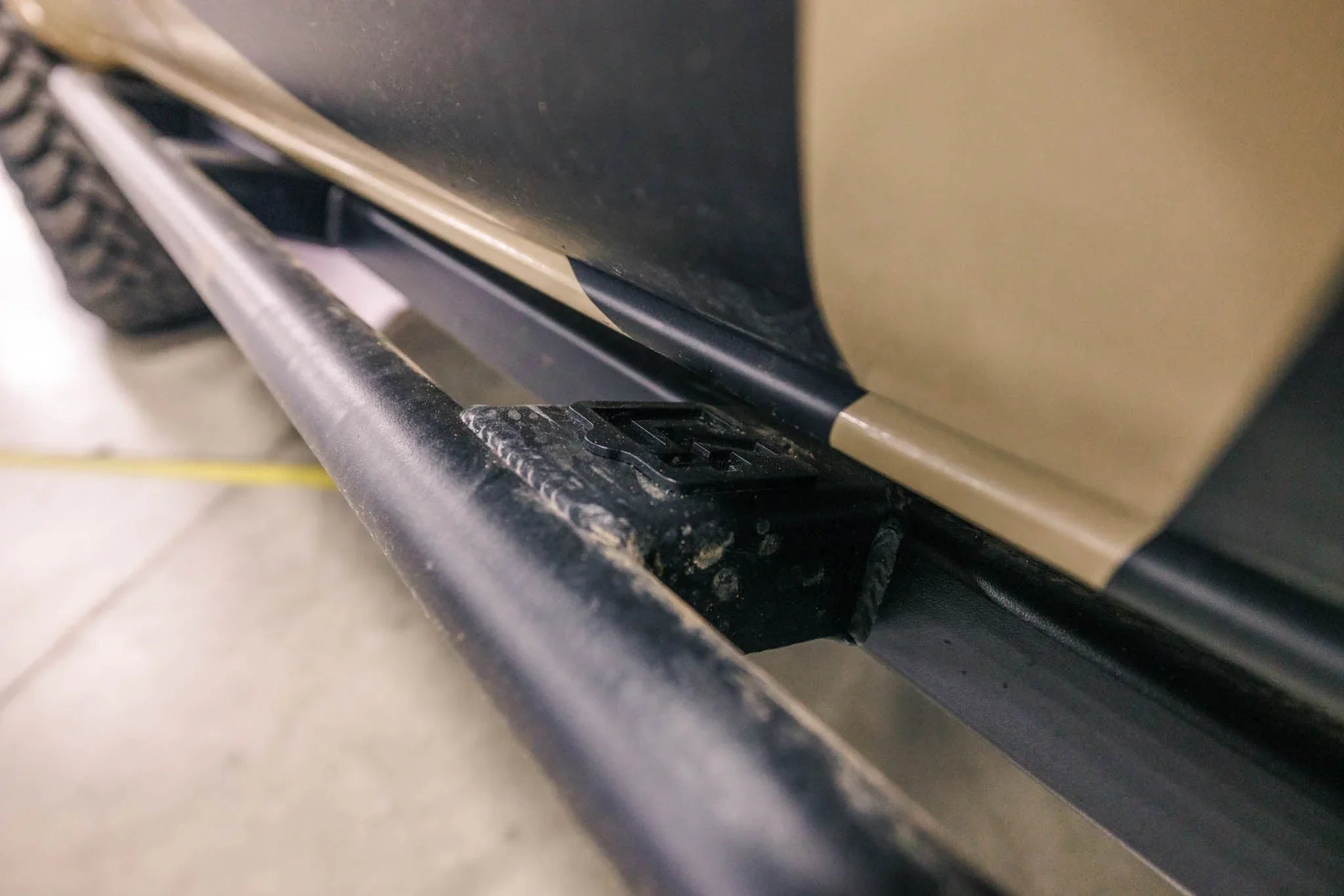 Close-up of rugged rock slider step mounted on off-road vehicle side panel