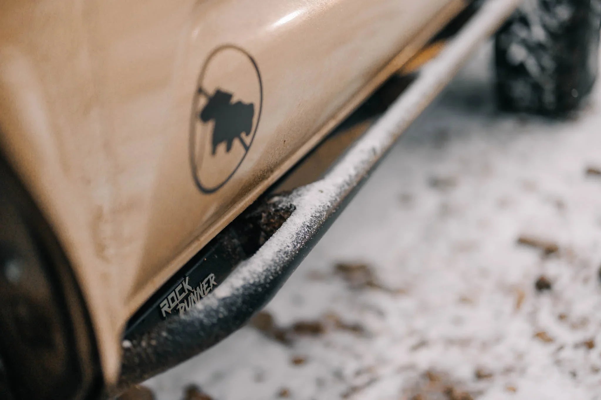 Rock Runner rock slider on off-road truck side panel in snowy outdoor setting