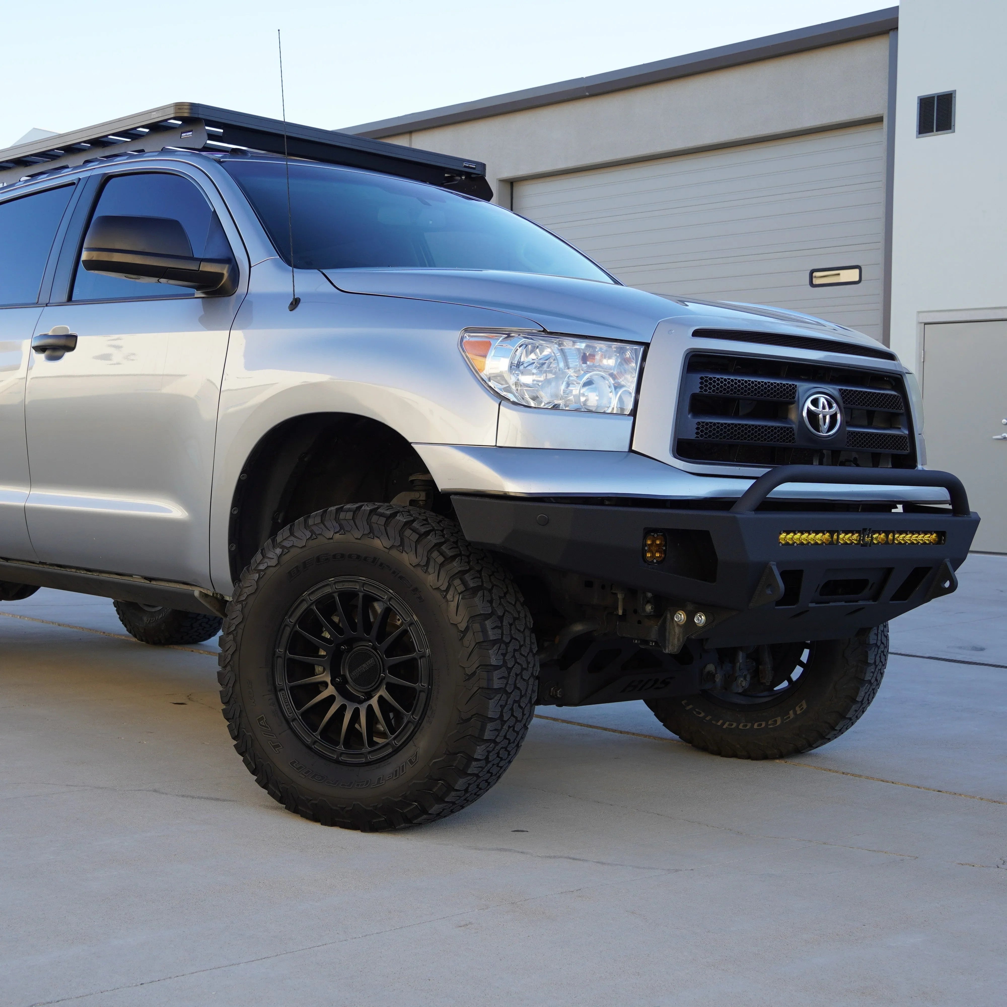 Toyota Tundra with off-road bumper, LED light bar, roof rack, and all-terrain tires