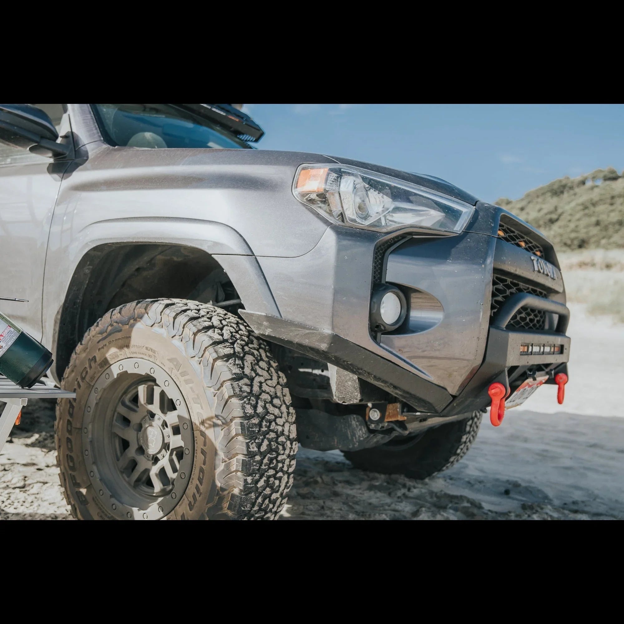 Toyota 4Runner with off-road bumper, winch, and all-terrain tires on sandy terrain