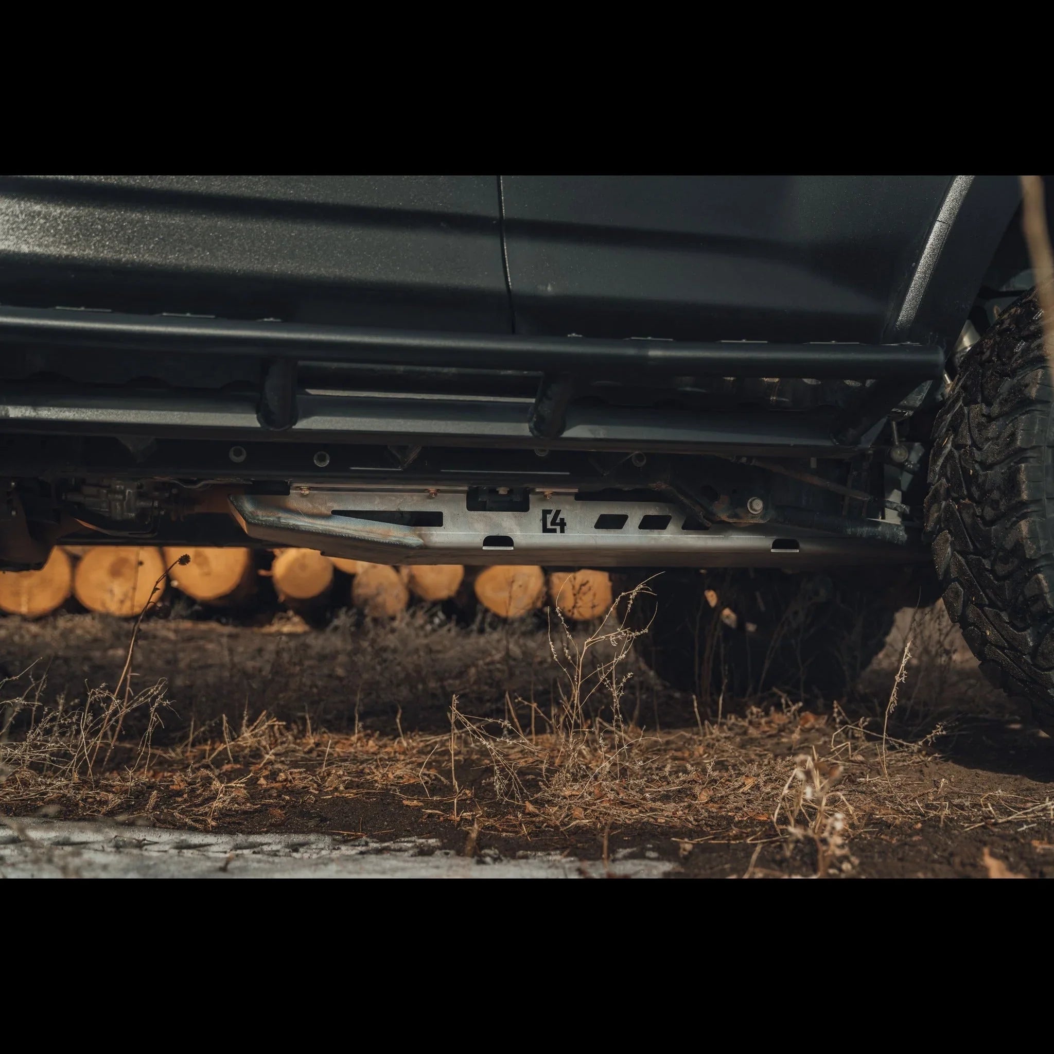 Off-road vehicle with skid plate and rock sliders on rugged terrain