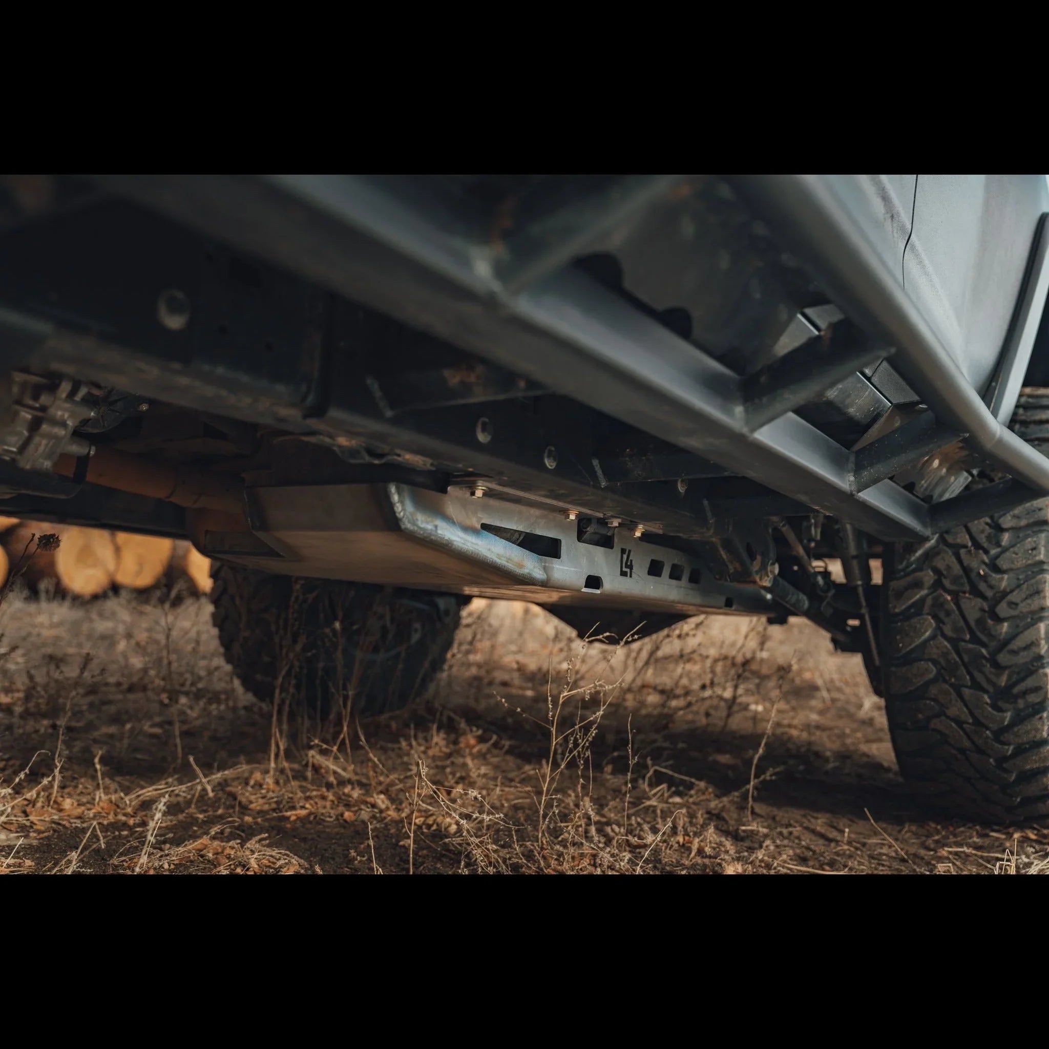 Close-up of off-road vehicle skid plate and rock sliders in rugged outdoor terrain