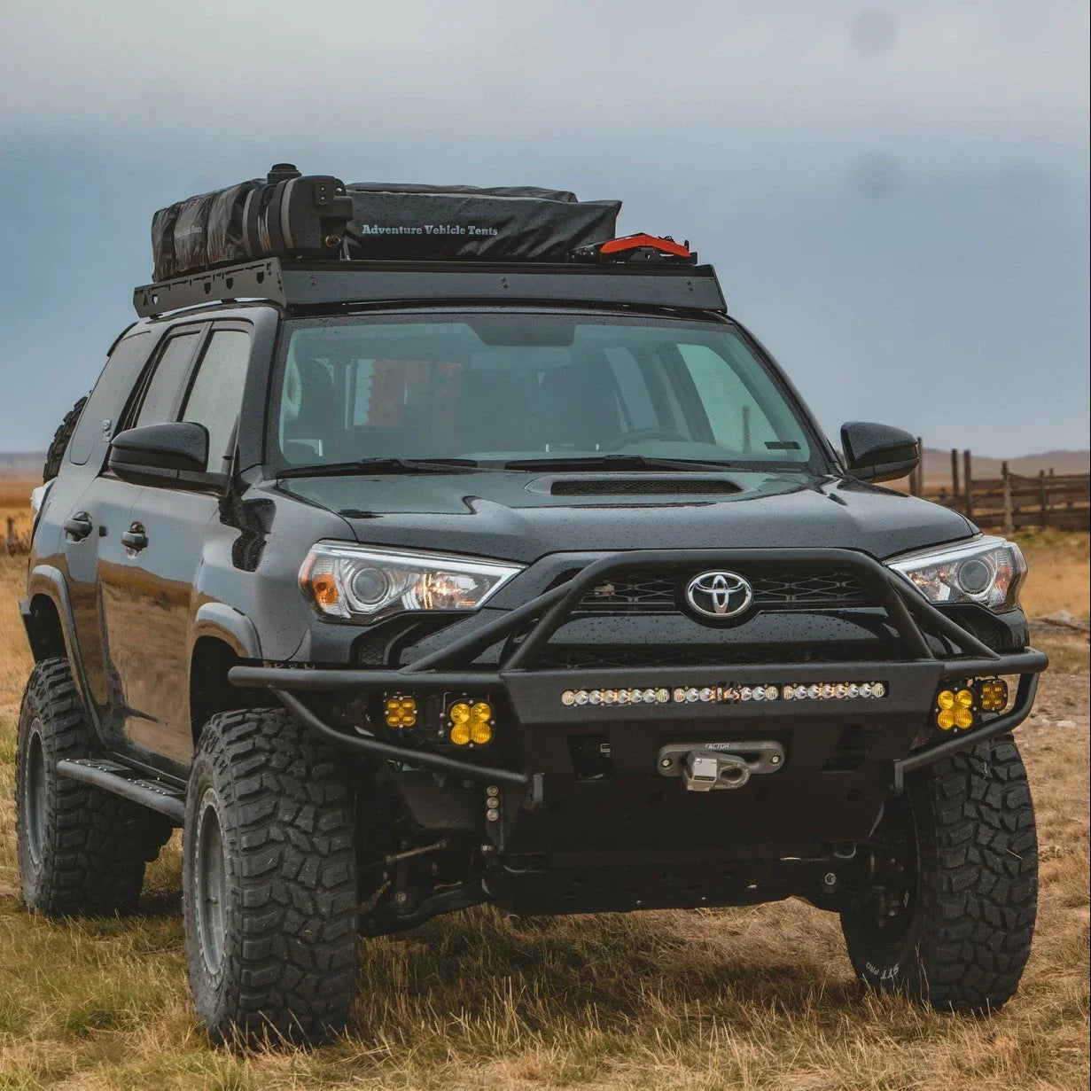 Toyota 4Runner outfitted for overlanding with roof rack tent and off-road accessories in field